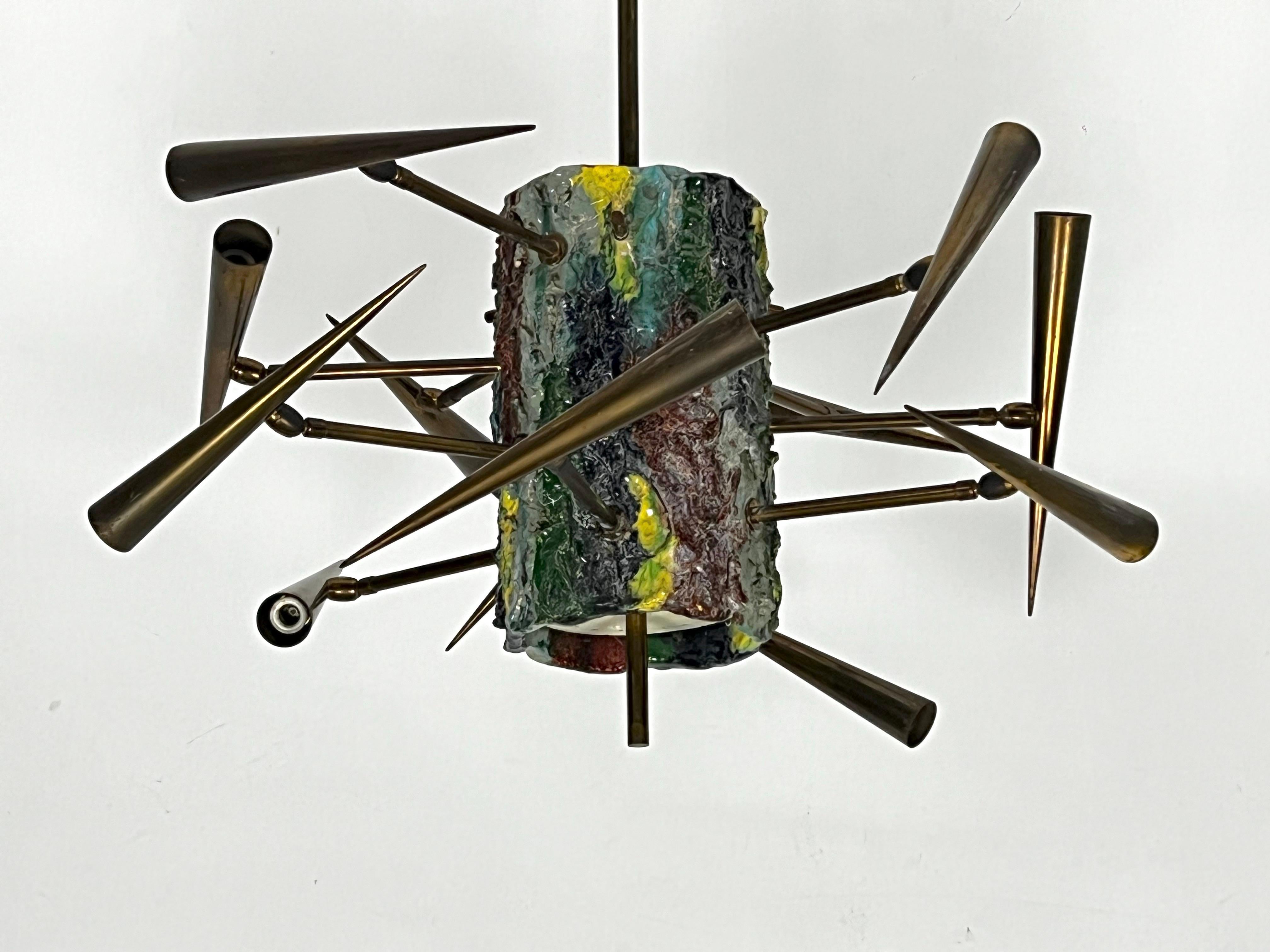 Mid-Century Sculptural chandelier composed of a ceramic painted cylinder and 12 brass arms with orientable cones. Made by thewell know Italian sculptor Leoncillo Leonardi in 1952.
Unaltered vintage condition with normal trace of age and use.