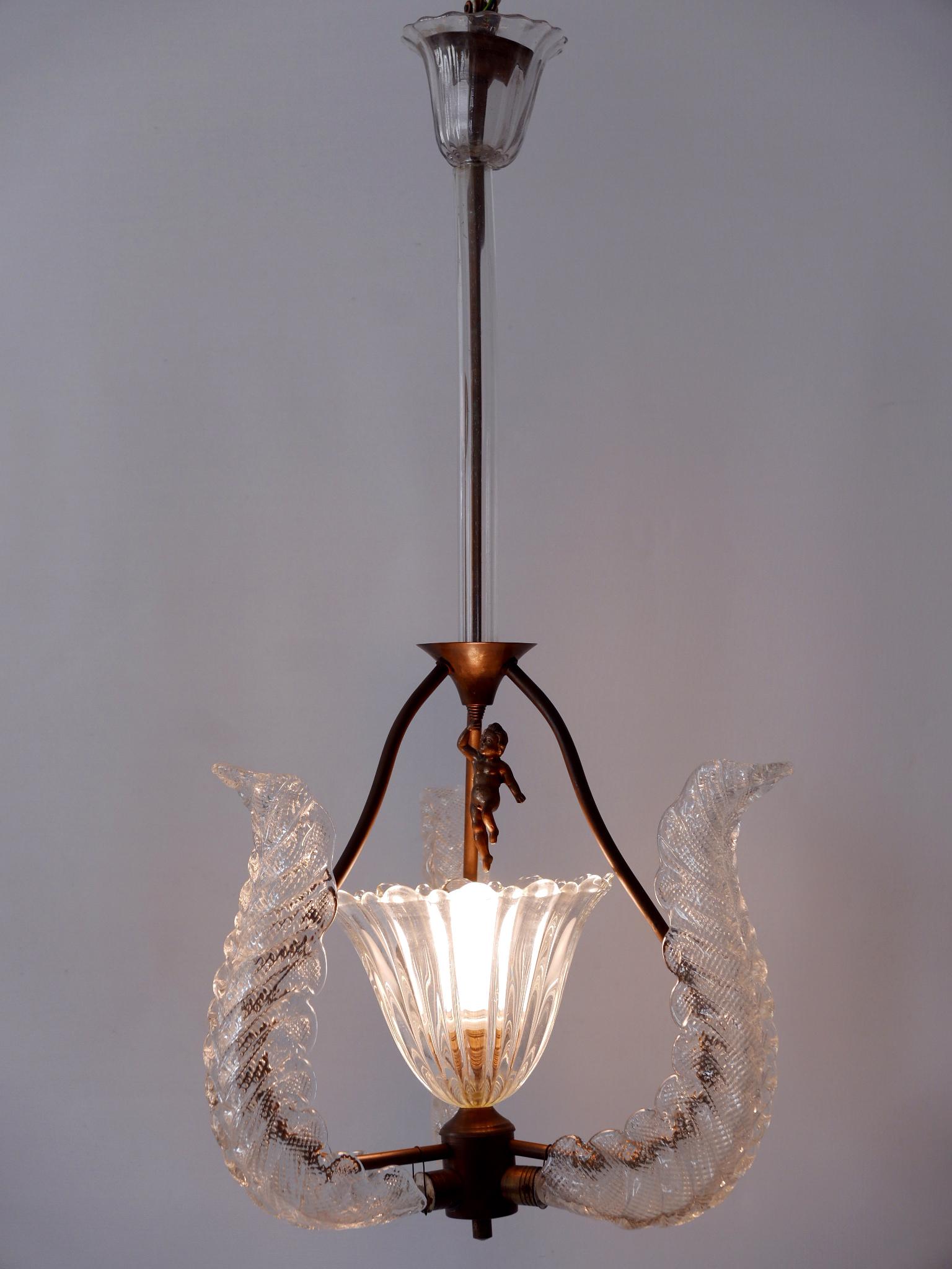 Gorgeous, highly decorative Mid-Century Modern 'Putti' pendant lamp or chandelier. Designed & manufactured by Barovier & Toso, Italy, 1950s.

Executed in Murano Glass and brass, the pendant lamp/chandelier needs 1 x E27 / E26 Edison screw fit bulb.