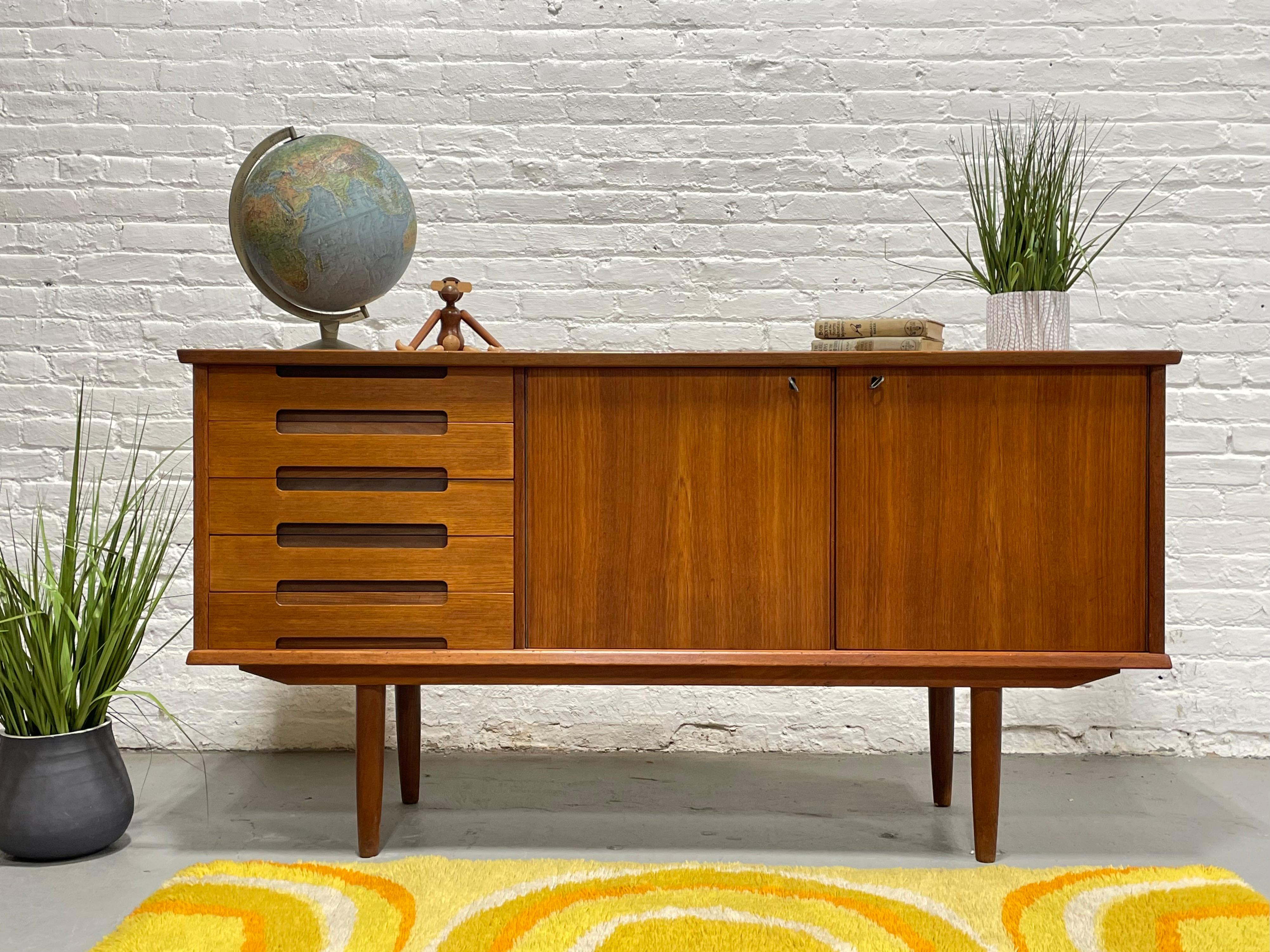 Sehr seltene Mid Century Modern Danish Teak Credenza / Media Stand mit herrlichen skulpturalen Schublade zieht, c. 1960's. Schlichtes, aber äußerst funktionales Design und die perfekte Aufteilung für einen Medienstand - großzügige Ablageflächen für