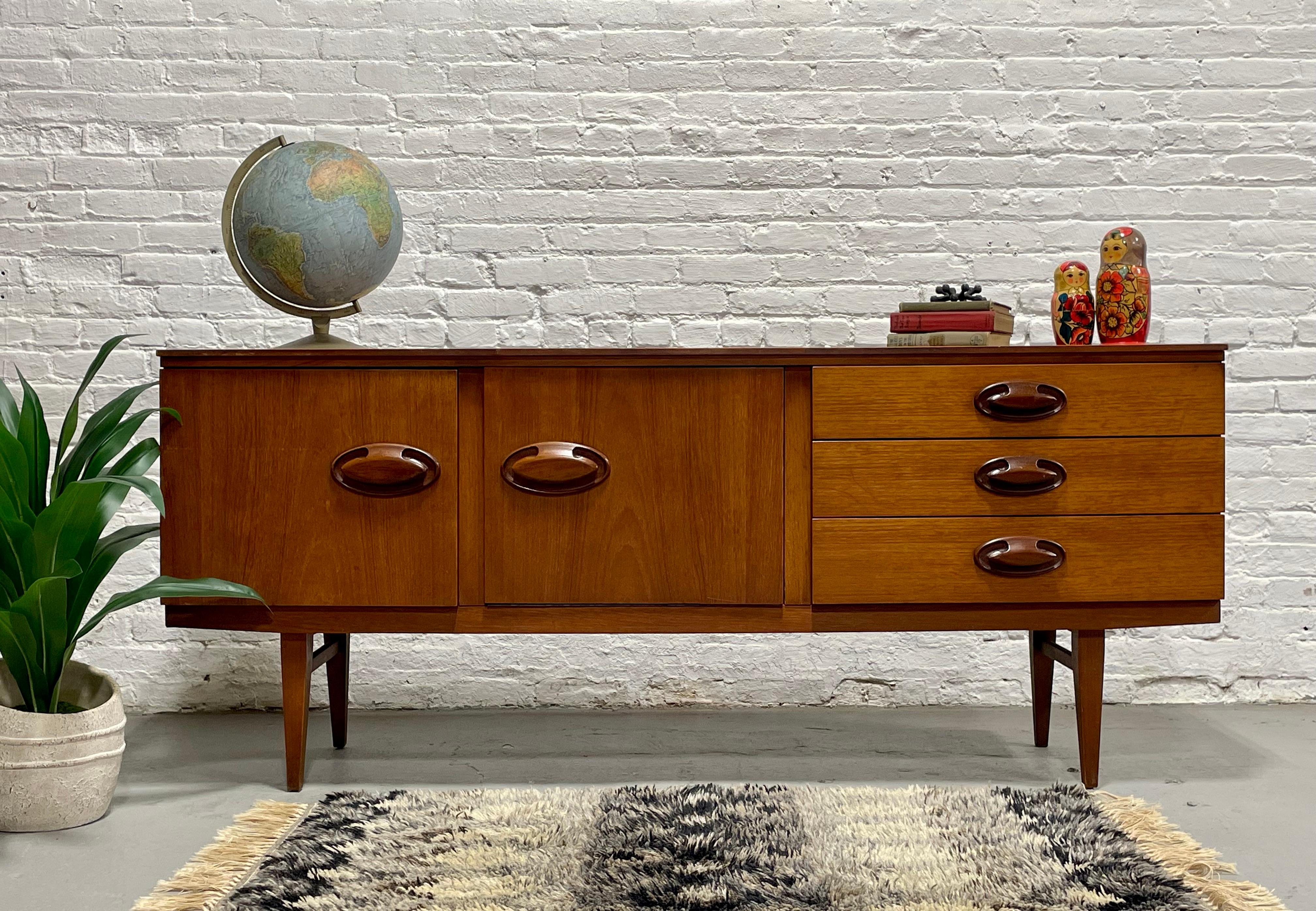 Rare crédence / meuble multimédia danois en teck moderne du milieu du siècle, avec de superbes poignées de tiroir sculpturales, vers les années 1960. Un design simple mais extrêmement fonctionnel et l'agencement parfait pour un meuble multimédia -