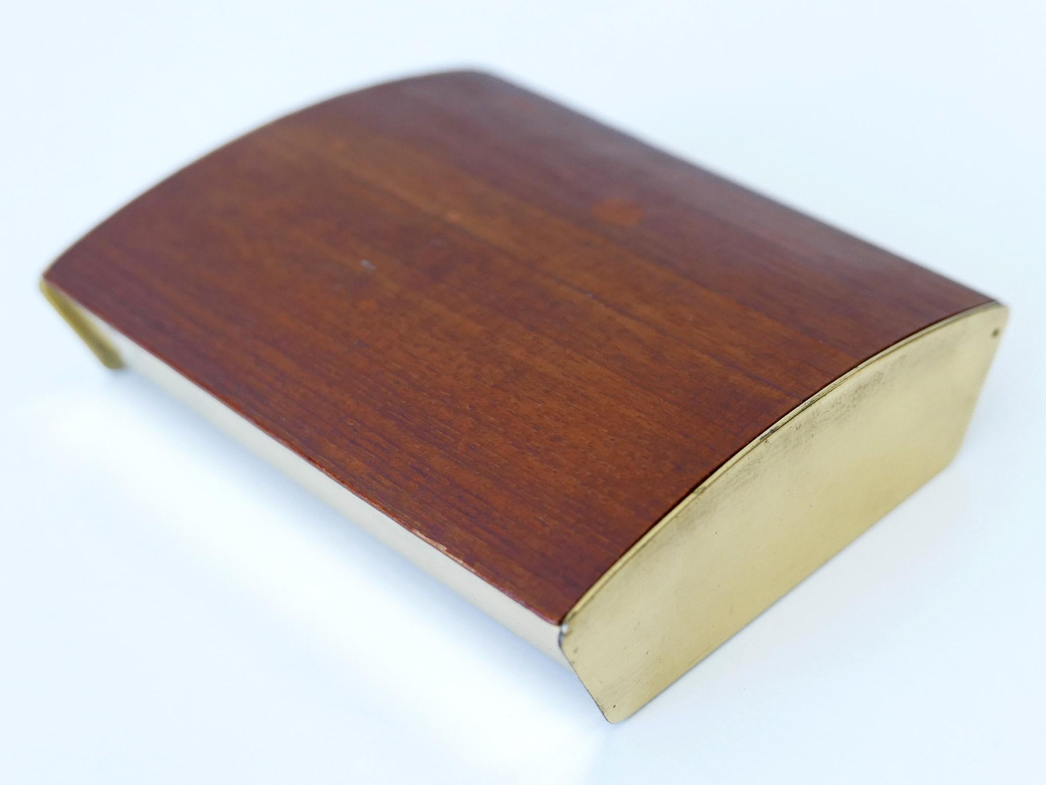 Extremely rare and elegant Mid-Century Modern cigar or cigarette box by Carl Auböck, Vienna, Austria, 1950s.

Executed in teak wood, cork and polished brass.

Dimensions: 
W 5.12 in. (13 cm)
D 4.33 in. (11 cm)
H 1.5 in. (3.8 cm)

Condition:
Good