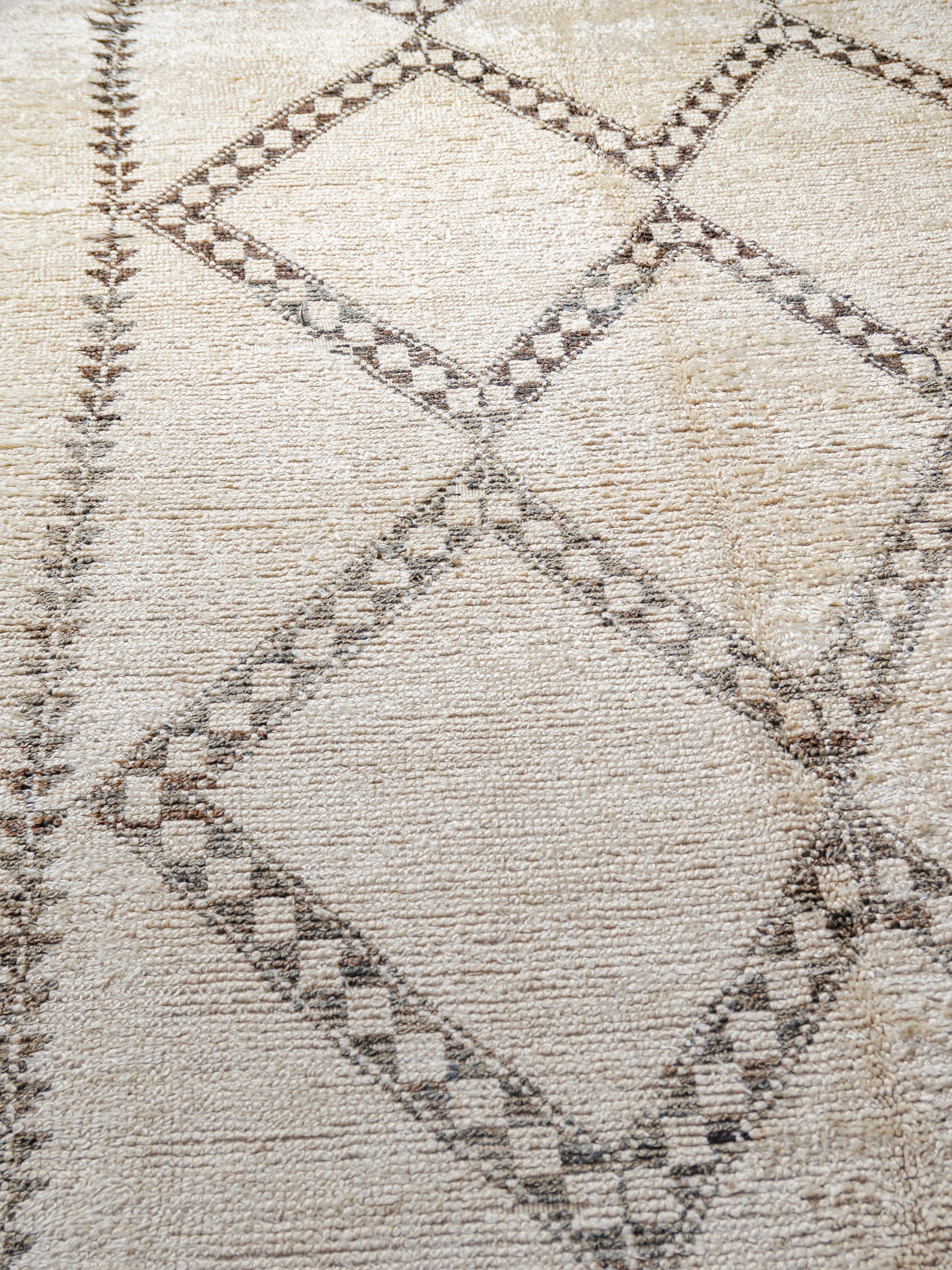 A minimalist vintage Beni Alaham featuring coupled large-scale lozenge motifs comprised of banded square forms. Vertical chains of double triangles hold the composition, forming symbols of protection. Woven in a mixture of deep neutral browns on an