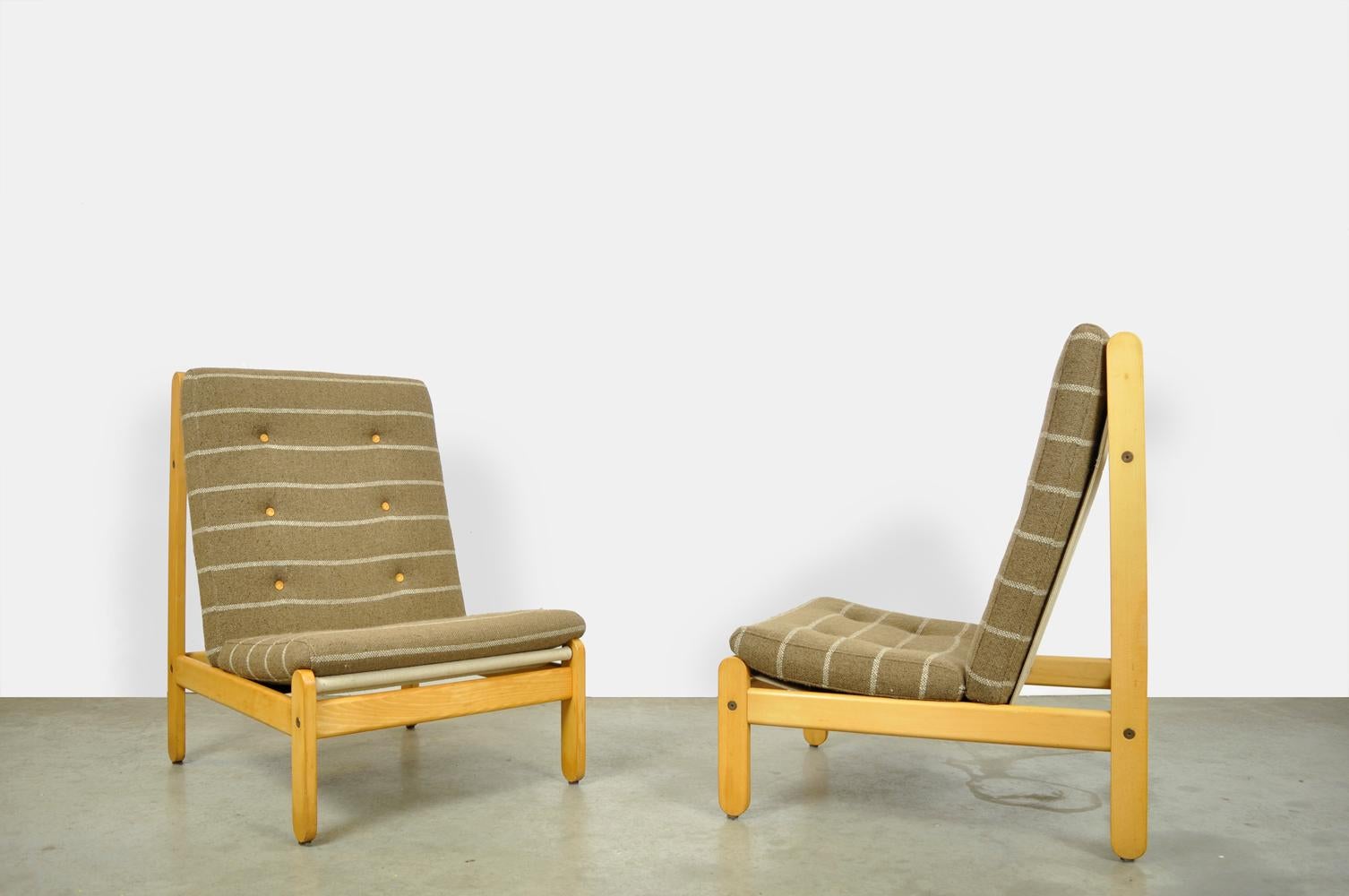 Special oak lounge armchairs designed by the Dane Bernt Petersen and produced by Schiang Furniture, 1960s.

The armchairs have an oak frame with a canvas seat in between. There are two padded brown woolen cushions on the canvas seat. Nice detail