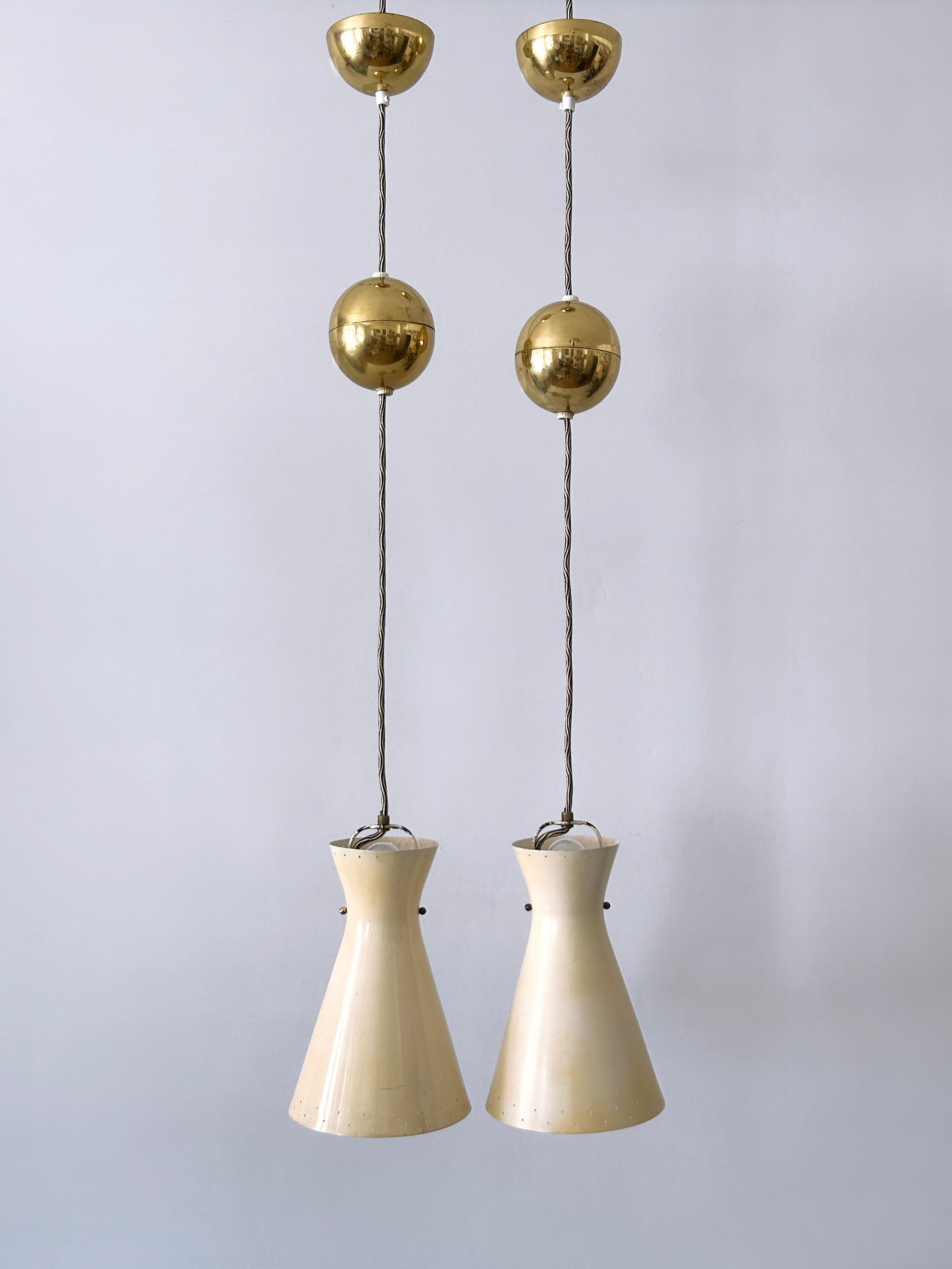 Extremely rare, elegant and highly decorative Mid-Century Modern pulley diabolo pendant lamps or hanging lights. Up and down lighting. Designed & manufactured probably by Vereinigte Werkstätten München, Germany, 1950s.

There are two identical