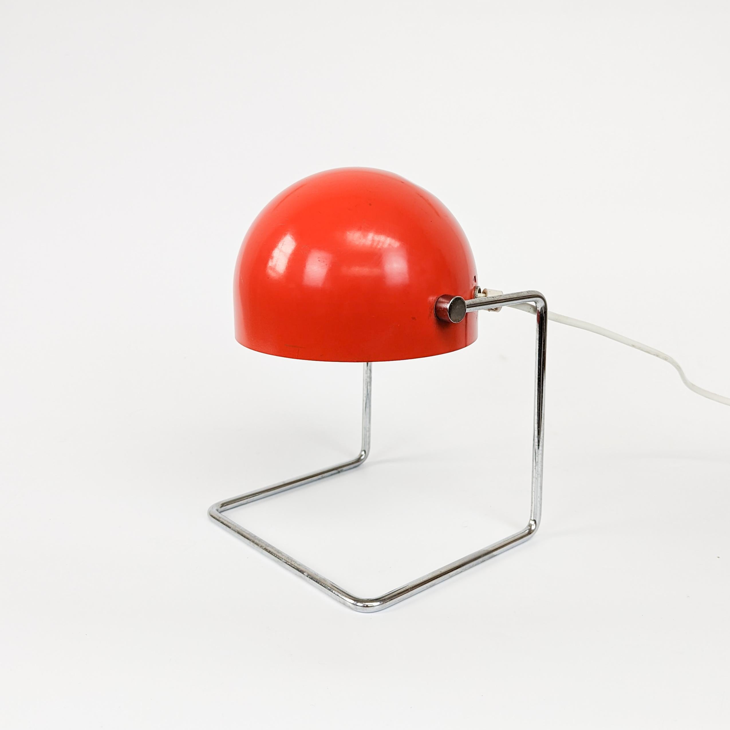 Iconic metal table lamp made in the 1960s by Napako under the mark 85104 according to the design of Josef Hurka. The lamp has a base made of bent chrome-plated iron, a metal shade with a red outer coating and rotating joints on the sides, which can