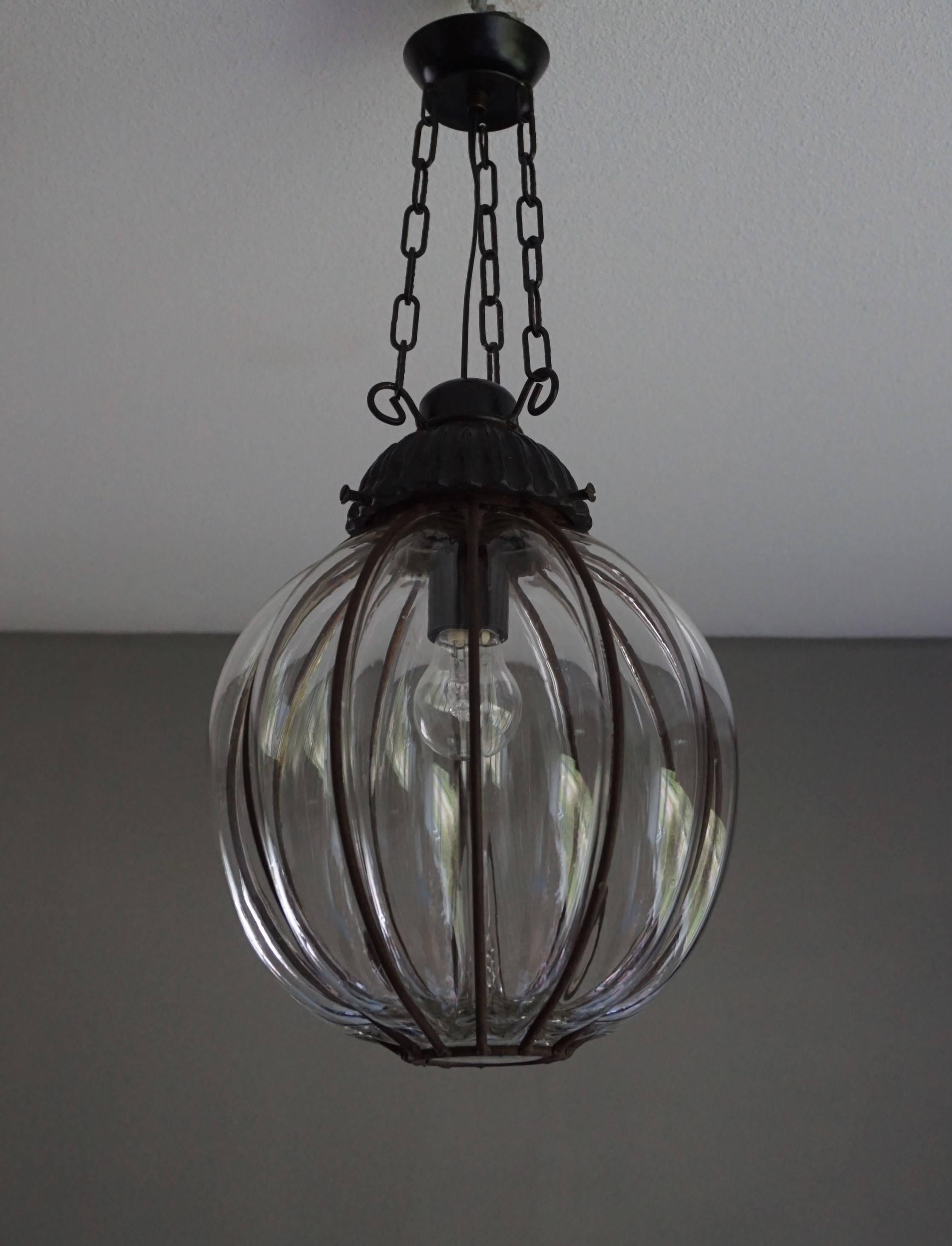 Timeless, circular shape Venetian pendant.

This rare midcentury pendant is mouthblown into a perfectly symmetrical and circular shape. The thick transparent glass below the strong black metal gallery makes it an absolute joy to look at, both on
