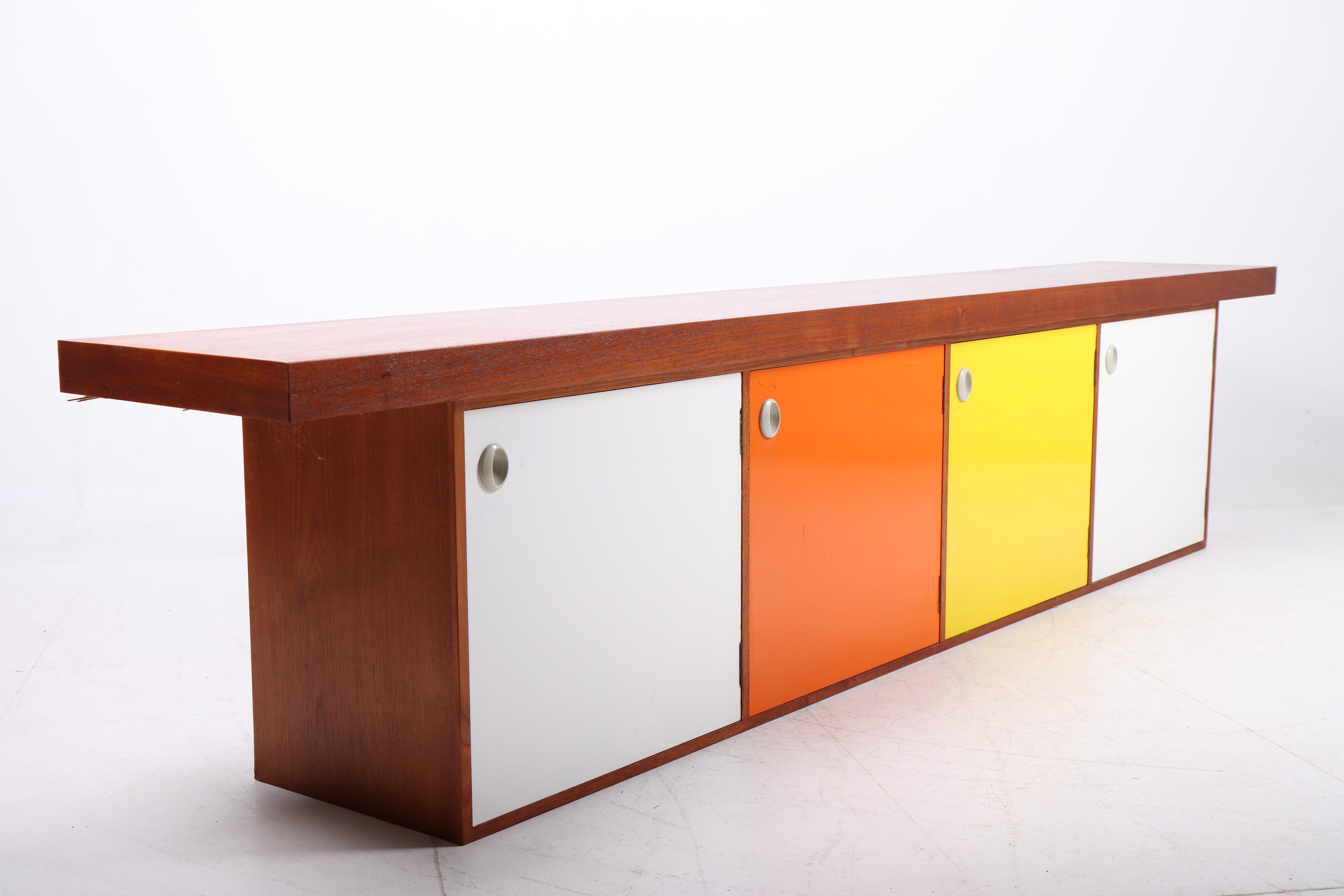 Floating sideboard in teak with original colored panels. Designed and made in Denmark in the 1950s. Great original condition.
