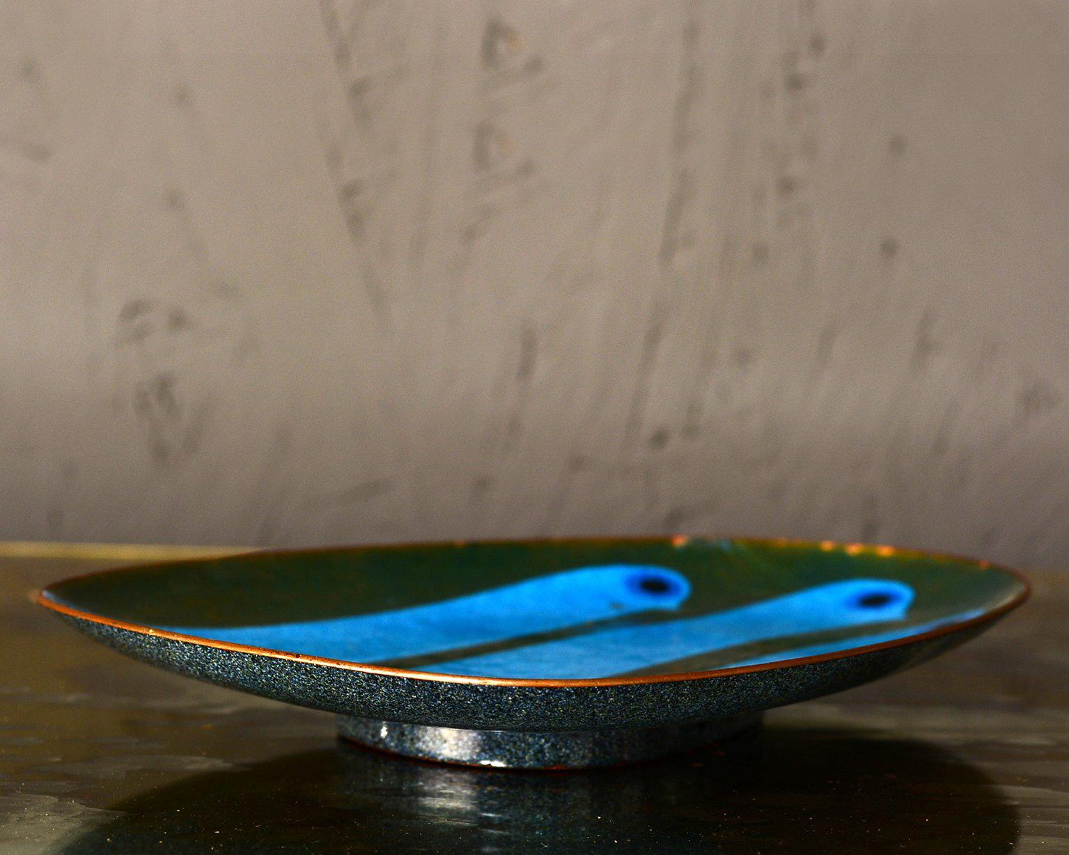 For your consideration a vintage dish with an oval/egg shape.

Very rare and unusual color (green and blue) combination. Very vibrant and beautiful modernist design.
Stamped with makers signature on the back.
Measures: 1