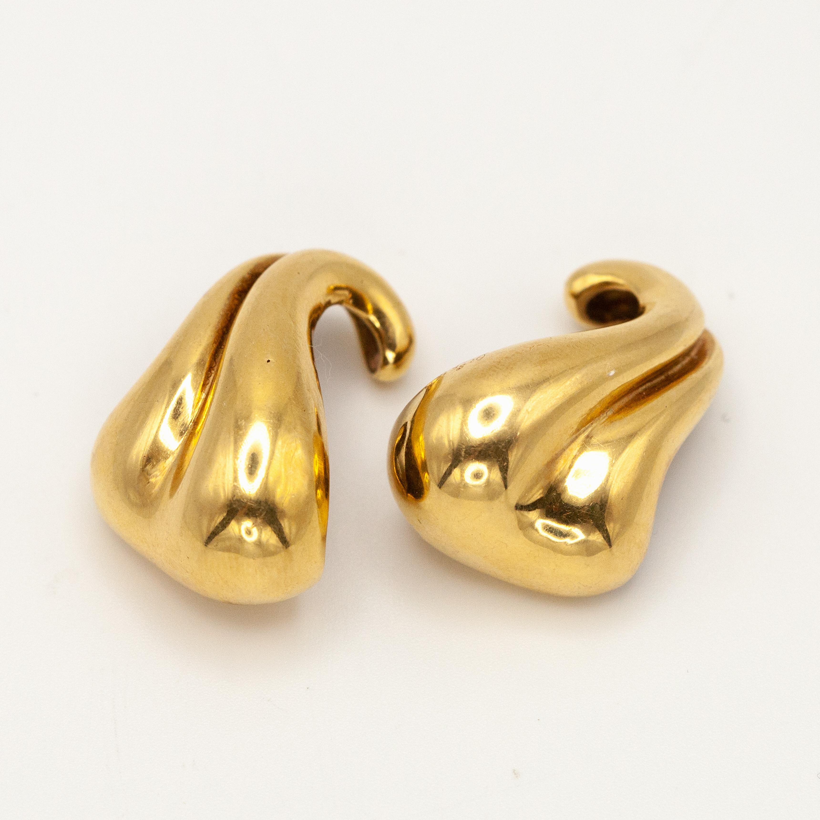 Rare MINAS SPIRIDIS solid 18K yellow gold modernist earrings. The curve design is meant to work as a hook over the intertragic notch of the ear. A very special pair of earrings indeed!

The Greek designer began designing pieces for Georg Jensen in