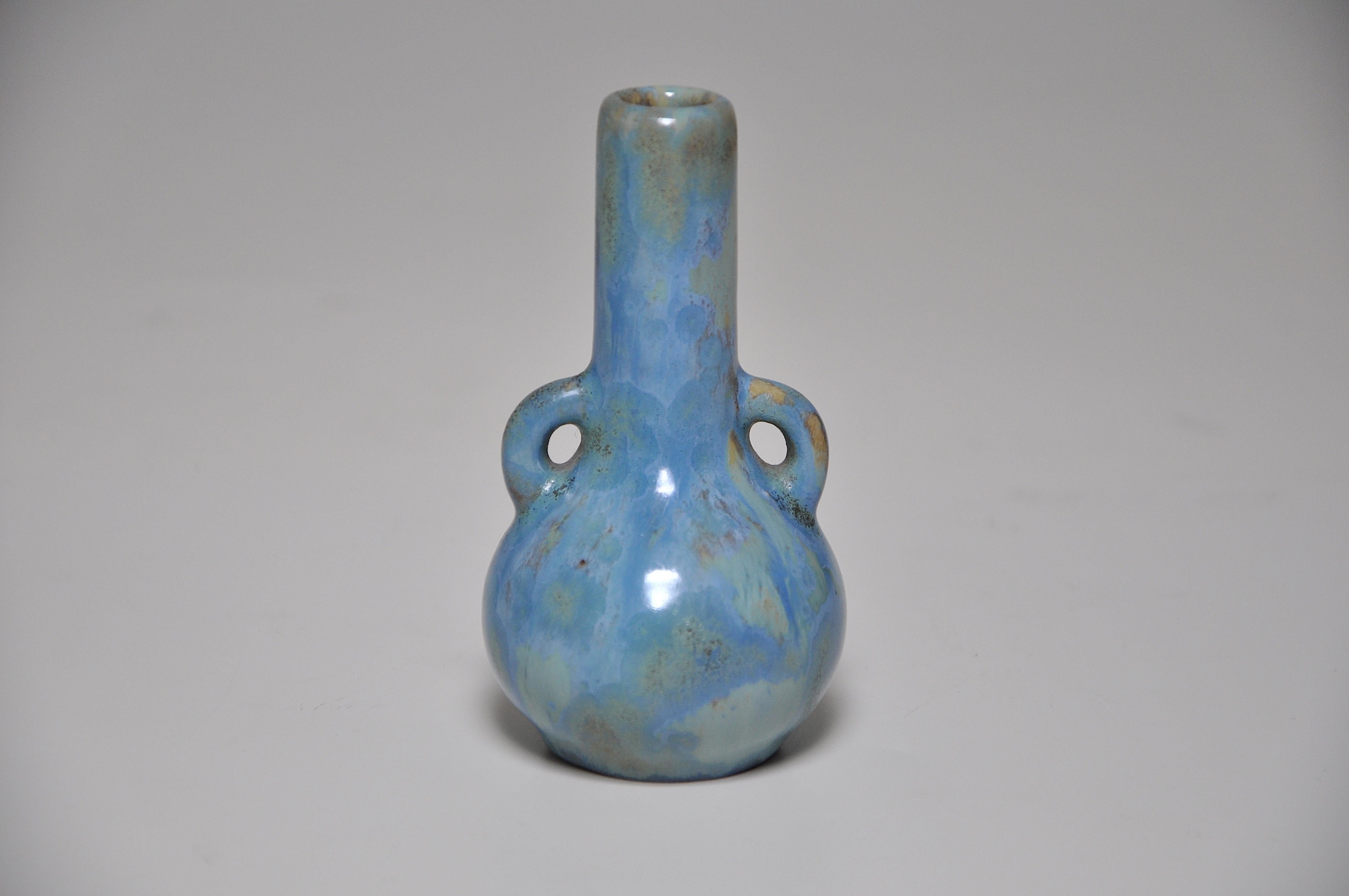 Exquis vase miniature en grès de forme bulbeuse, avec de minuscules anses jumelles et un long col, recouvert d'une glaçure bleue intense et fluide, cristalline par endroits, sur un fond jaune. Par l'atelier de céramique français 'Pierrefonds' dans