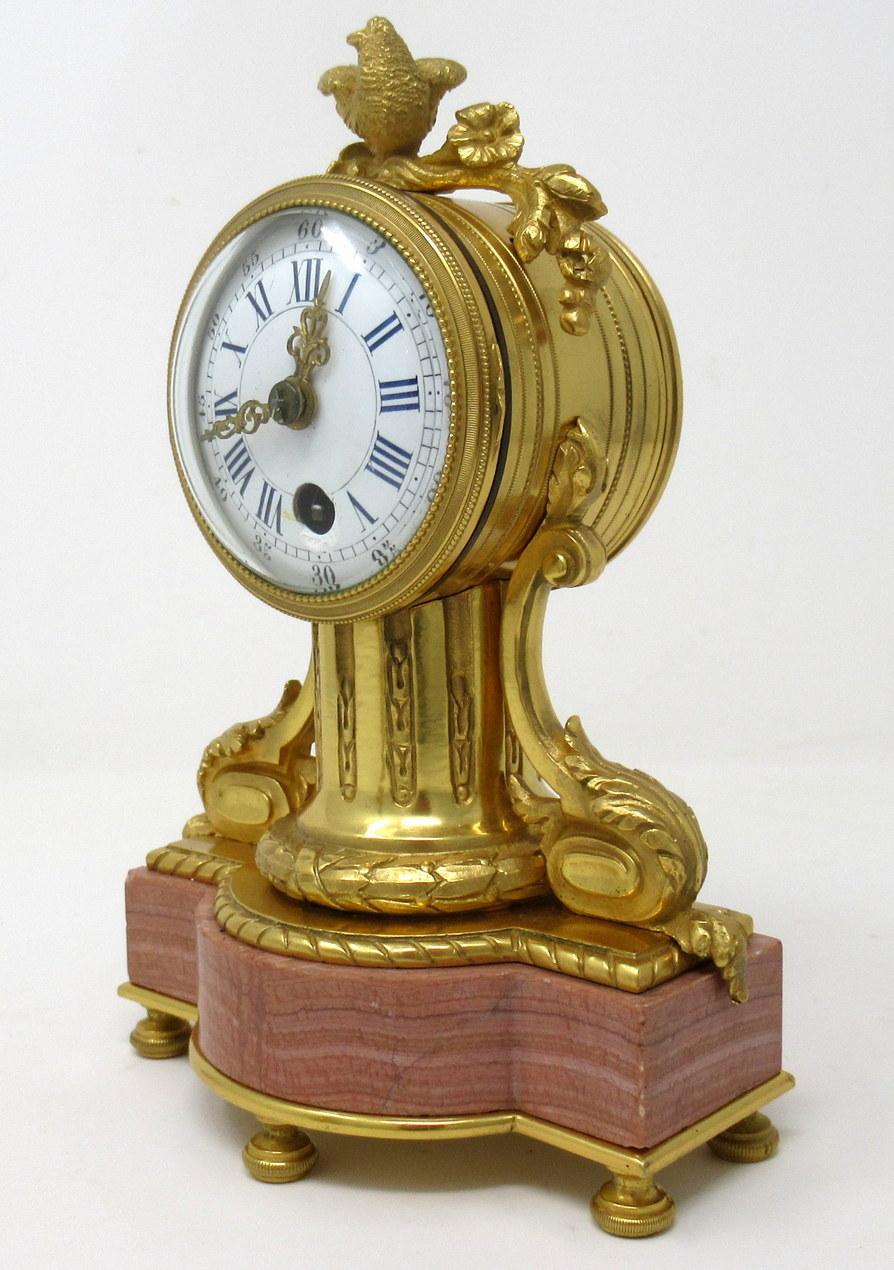 A fine early to mid-19th century French ormolu mantle clock garniture of outstanding quality and compact proportions.

The circular white enamel dial having blue Roman hour numerals, black outer Arabic five-minute markings, gilt –brass decorative