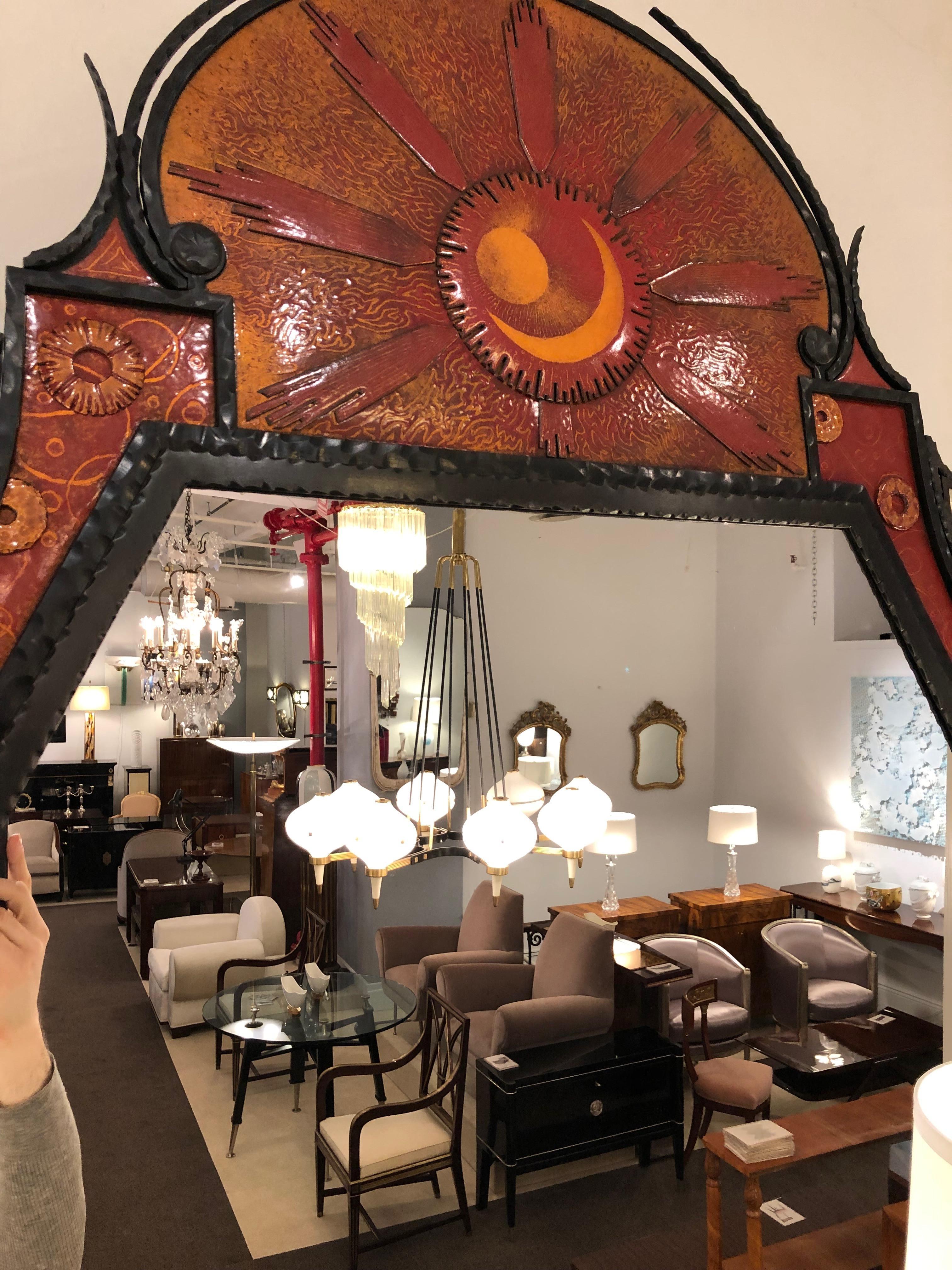 Rare and unusual mirror designed by André Dubreuil
Wrought iron with four cabochon mountain crystals 
and enameled insets in red, burnt orange and gold.
 