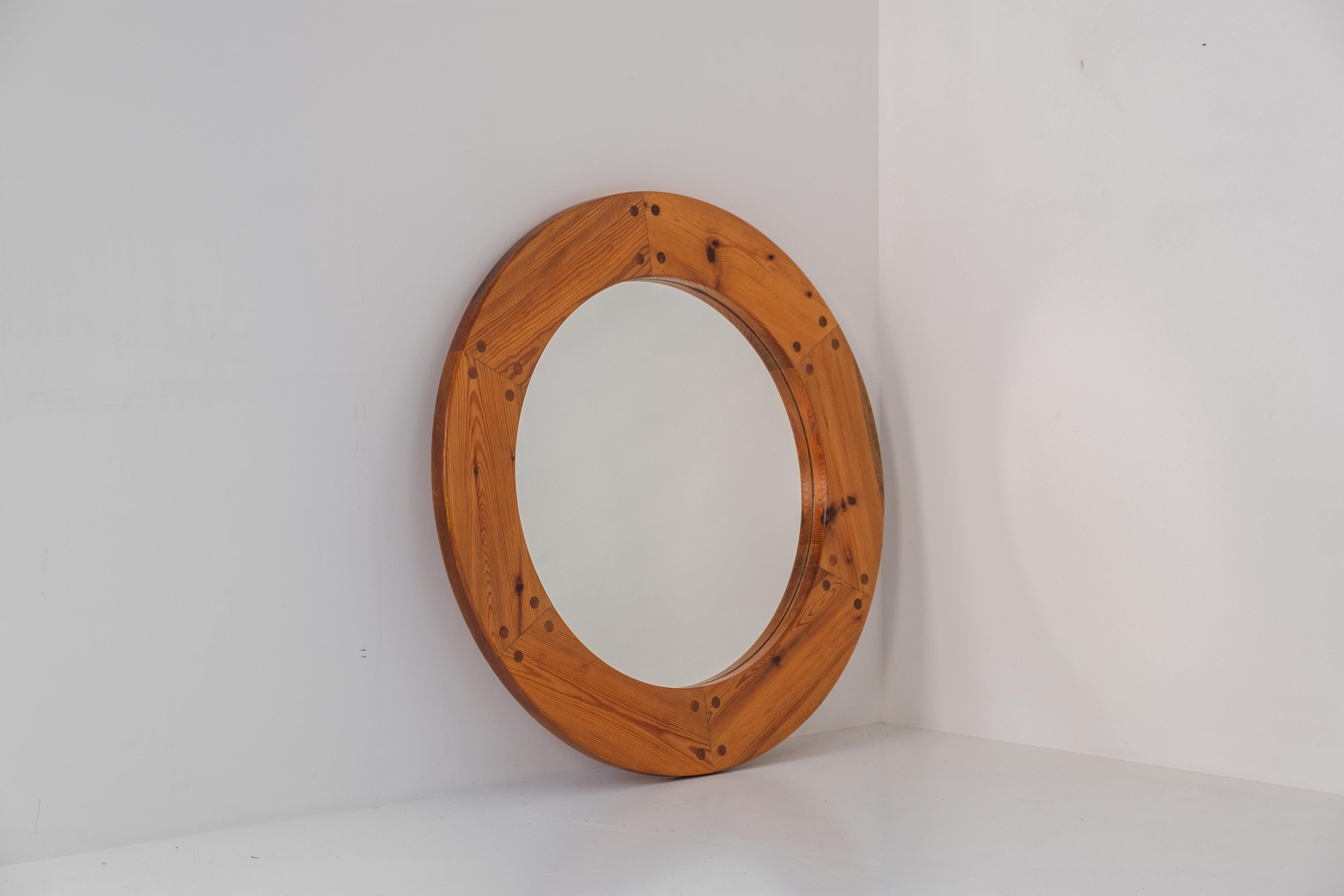 Lovely round mirror by Uno & Östen Kristiansson for Luxus Vittsjö Möbelfabrik Sweden, 1960s. This large mirror has a solid pine wooden frame with decorative integrated wooden nails. Presented in its original and good condition with only minor wear.