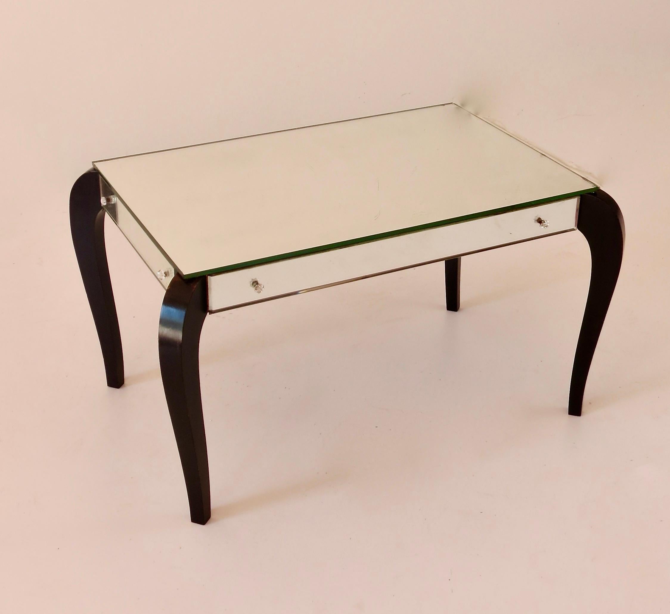 Extremely rare occasional coffee table, circa 1935
mirrored glass, ebonized wood, seven little glass screw cover (one missing)
all original condition
in the style of Fontana Arte (see Phillips Design Auction New York 11/06/2014 lot 67 for related