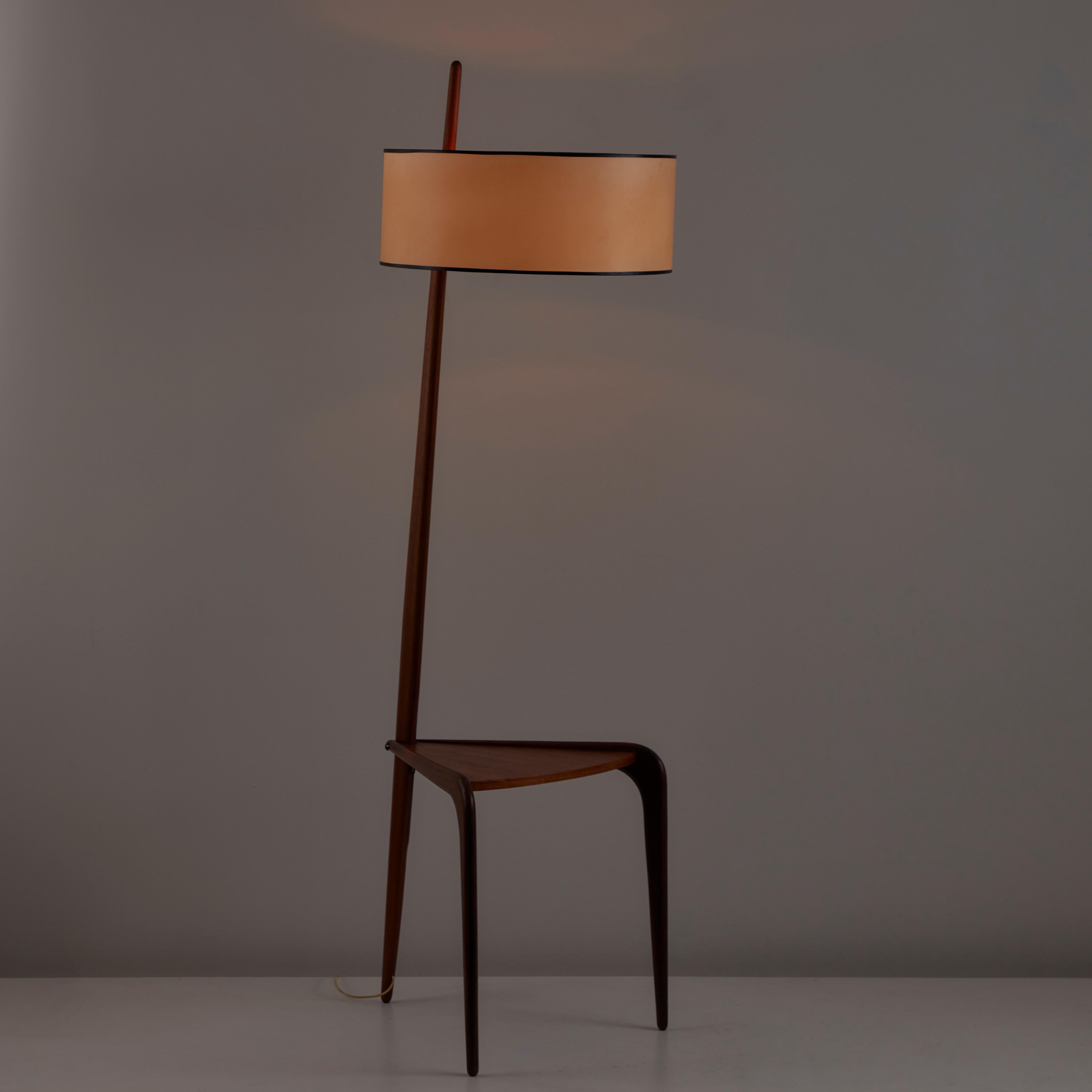 Model 167.A82 Floor Lamp by Rispal. Designed and manufactured in France, circa 1950s. Rare floor lamp featuring a soft wooden frame, parchment shade, and a three legged base and end table surface seamlessly included in the frame. This lamp holds two