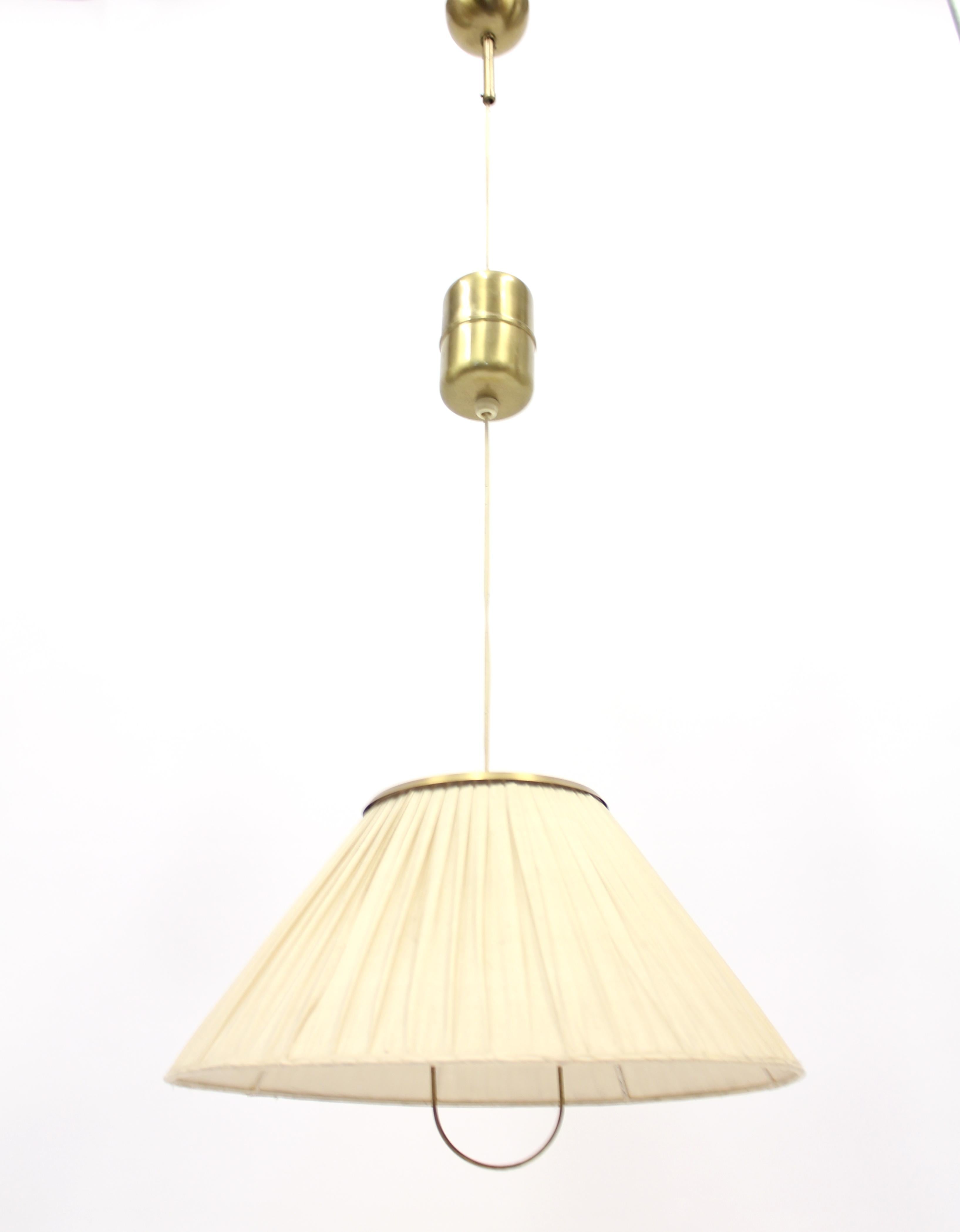 Rare height adjustable ceiling lamp in brass, model 1844, by Josef Frank for Svenskt Tenn. This is an early production, all original parts including the double layered fabric witch is in a good vintage condition: Two rips on the inside of the shade