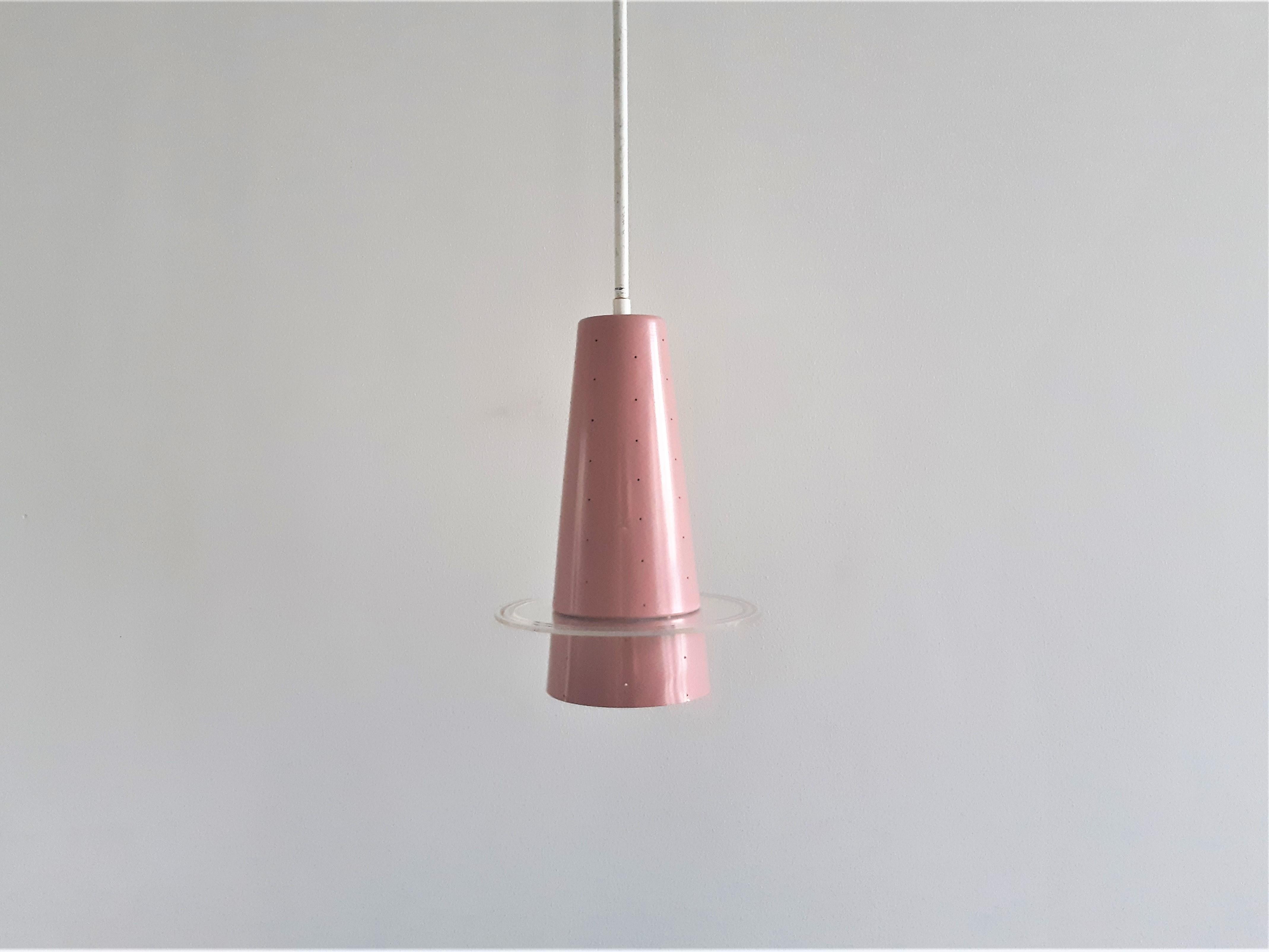 This rare and very elegant pendant lamp, model 205, was made by the Dutch company Evenblij in the 1960's. It has a pink metal conical perforated shade provided with a clear plexiglass disc that gives a stunning and magical light when lit. This lamp