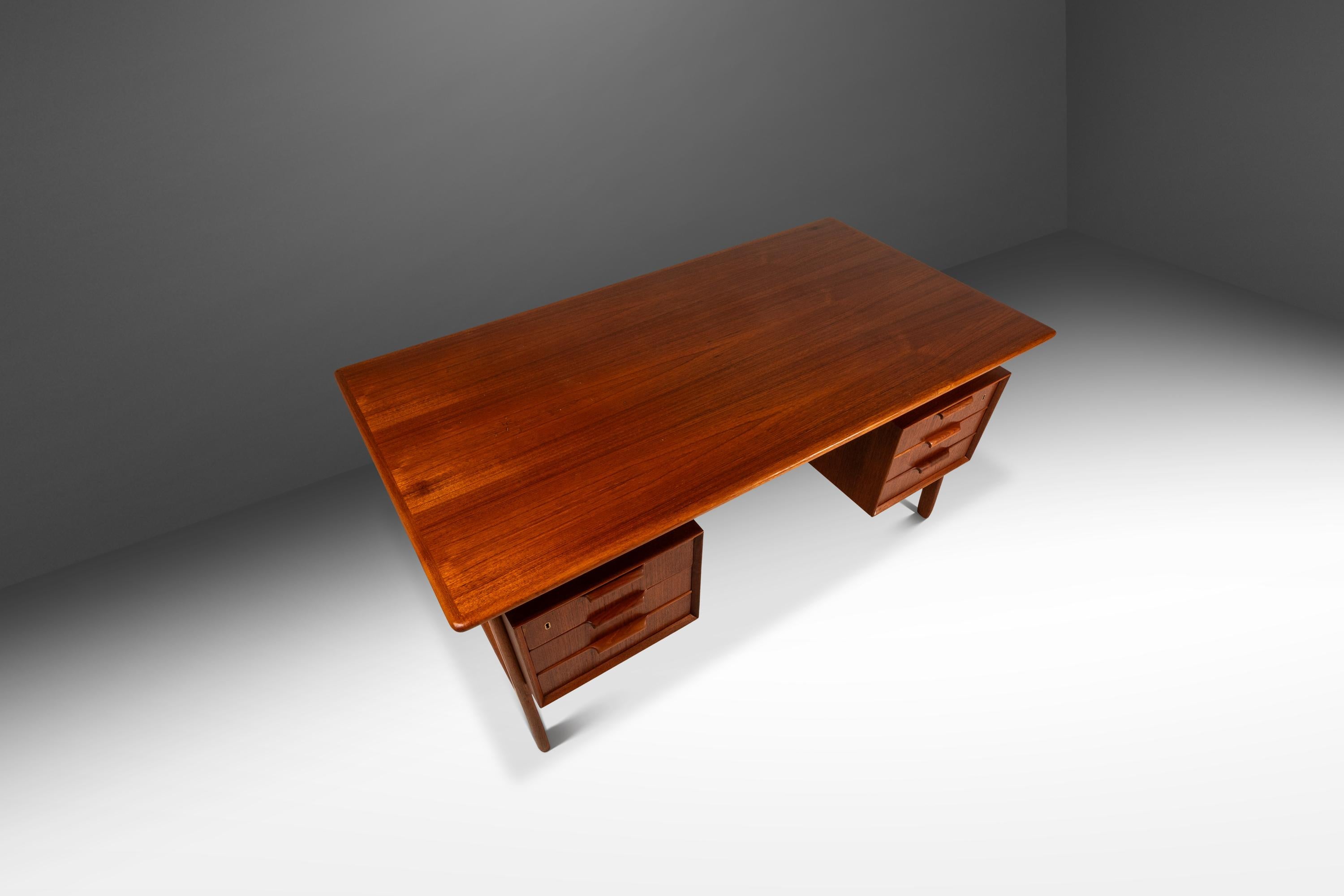 Questo raffinato scrittoio Model 75 di Omann Jun Møbelfabrik, realizzato negli anni '60, incarna la sobria eleganza del design danese del Mid-Century. Realizzata in ricco teak con una calda finitura naturale, la scrivania presenta linee pulite, una