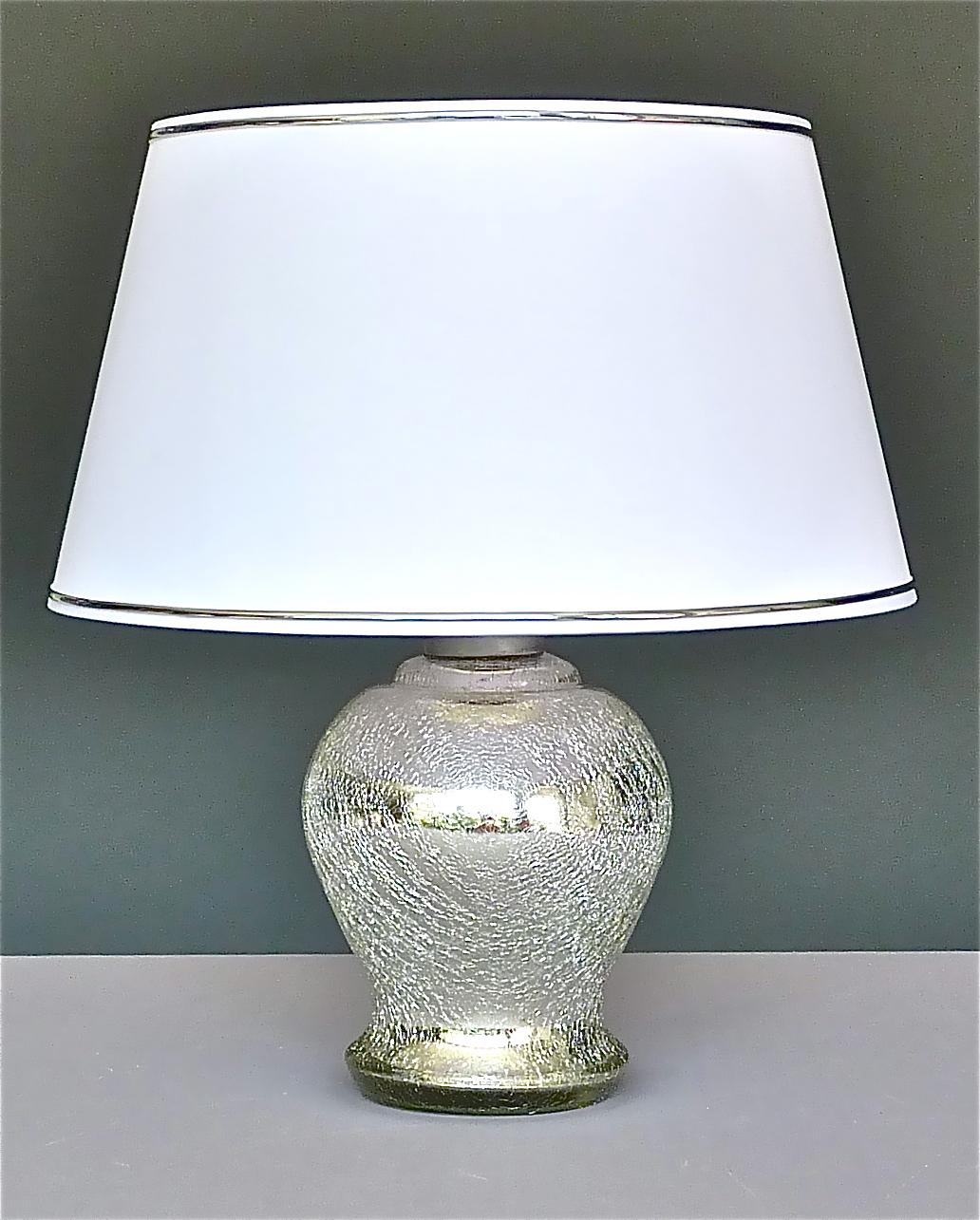 Rare Modernism Art Deco table lamp in thick silver mirrored glass with crackle effect finish which can be dated France, circa 1930s. It has a silver enameled metal fixture and a black plastic fitting for one E 27 screw bulb to illuminate. Wiring,