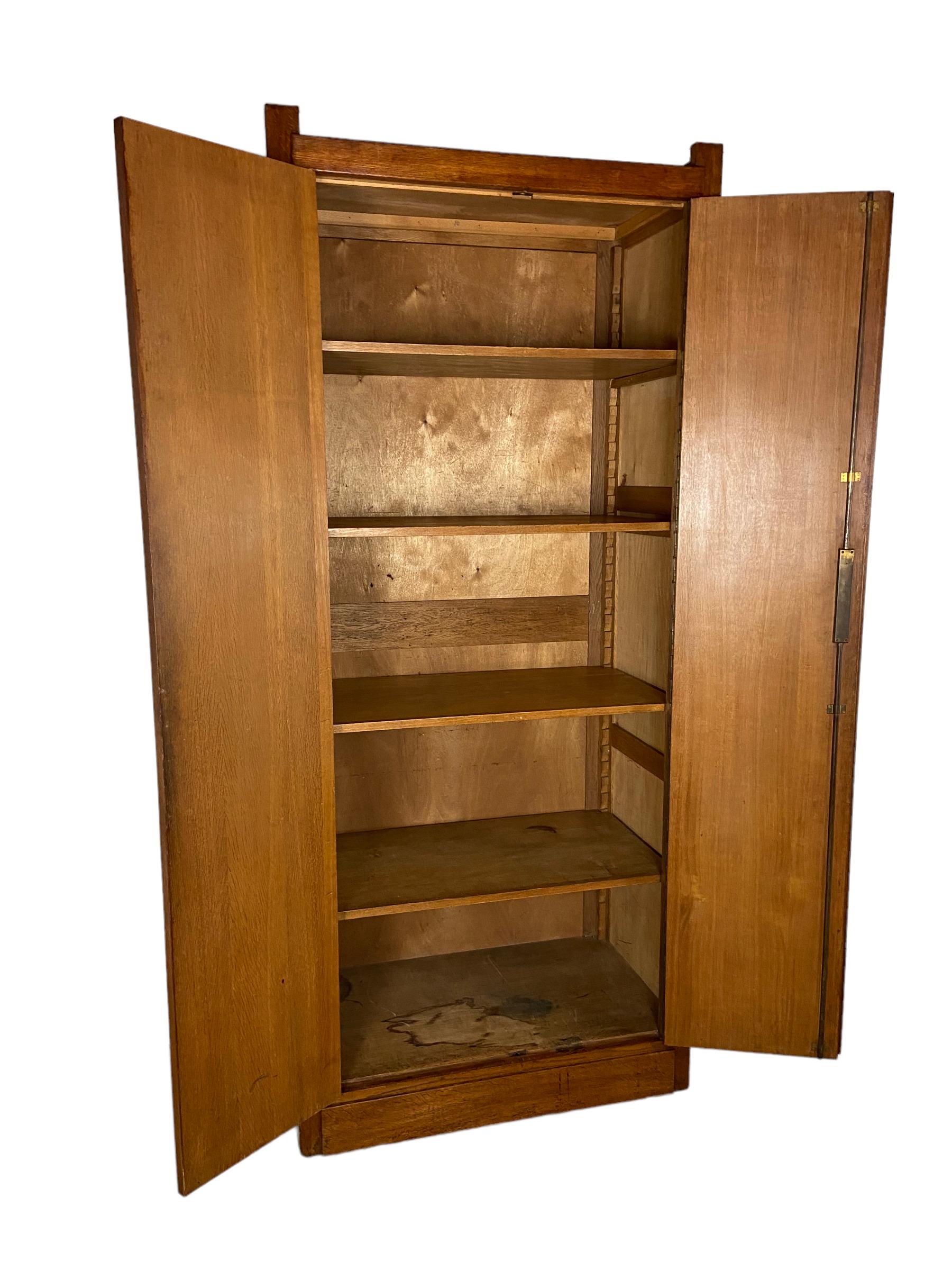 Rare modernist cupboard made of oak wood in The Netherlands in the 1920s. This high cabinet was used in a post office in the 1920s and 1930s. The 4 shelves are adjustable. The lock works good. This vintage object is in a good condition but it shows