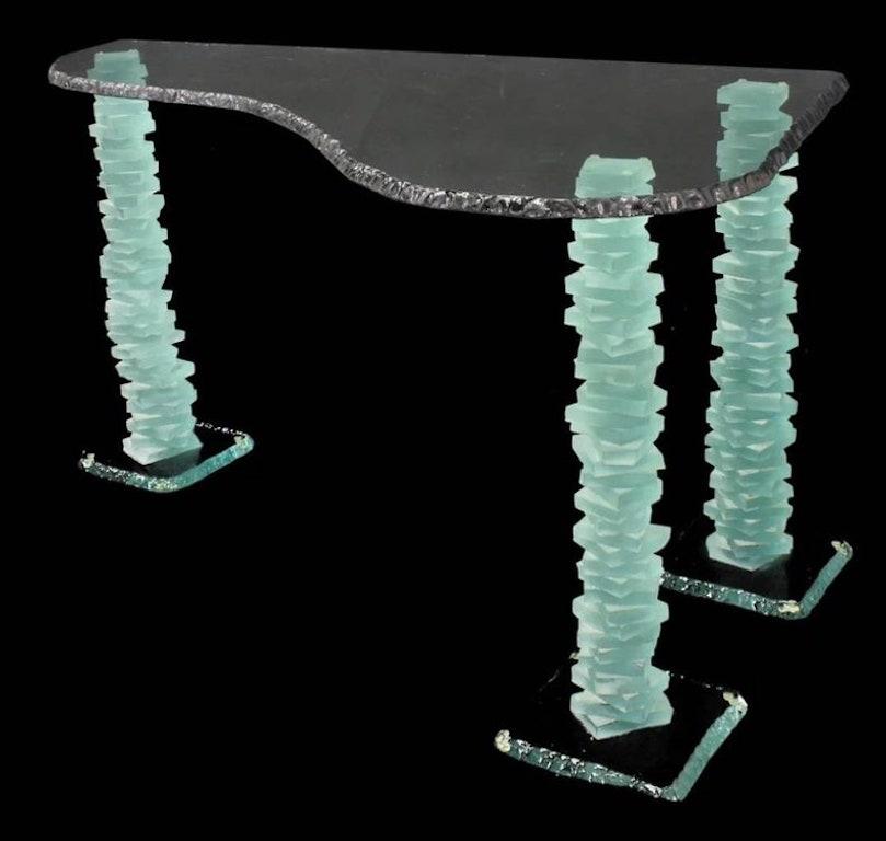 A spectacular, Modern sculptured glass table, from the last quarter of the 20th century, in the manner of Danny Lane (United States, b.1955). This stunning table features a floating, free-form, thick crystal glass tabletop with tinted edge, on three