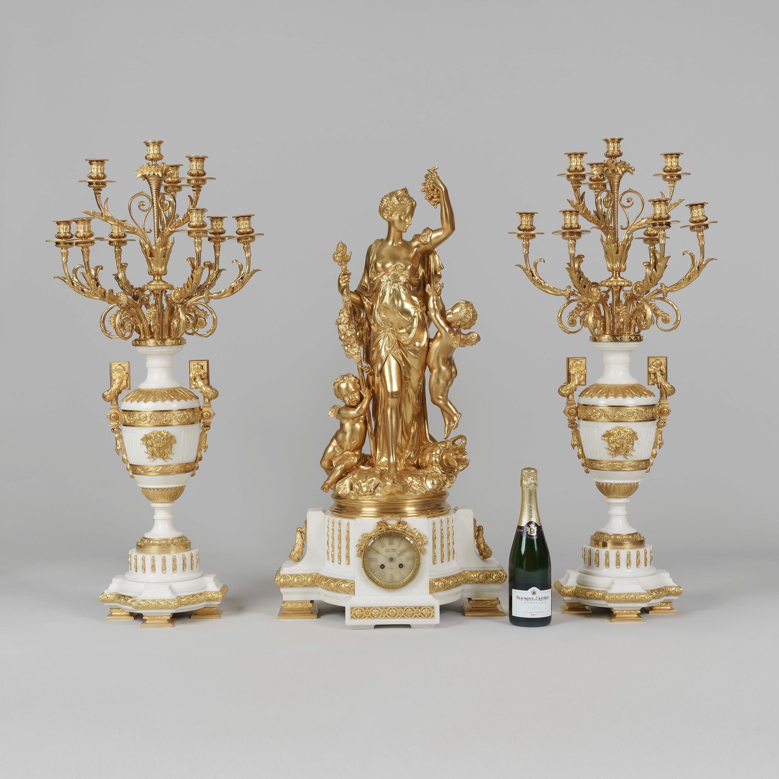 An Exhibition Quality Garniture de Cheminée
By Jules Graux of Paris

Of important size and supreme quality, the mantle clock constructed from white Carrara marble, rising from ormolu supports and decorated with laurel wreaths, guilloches, and a