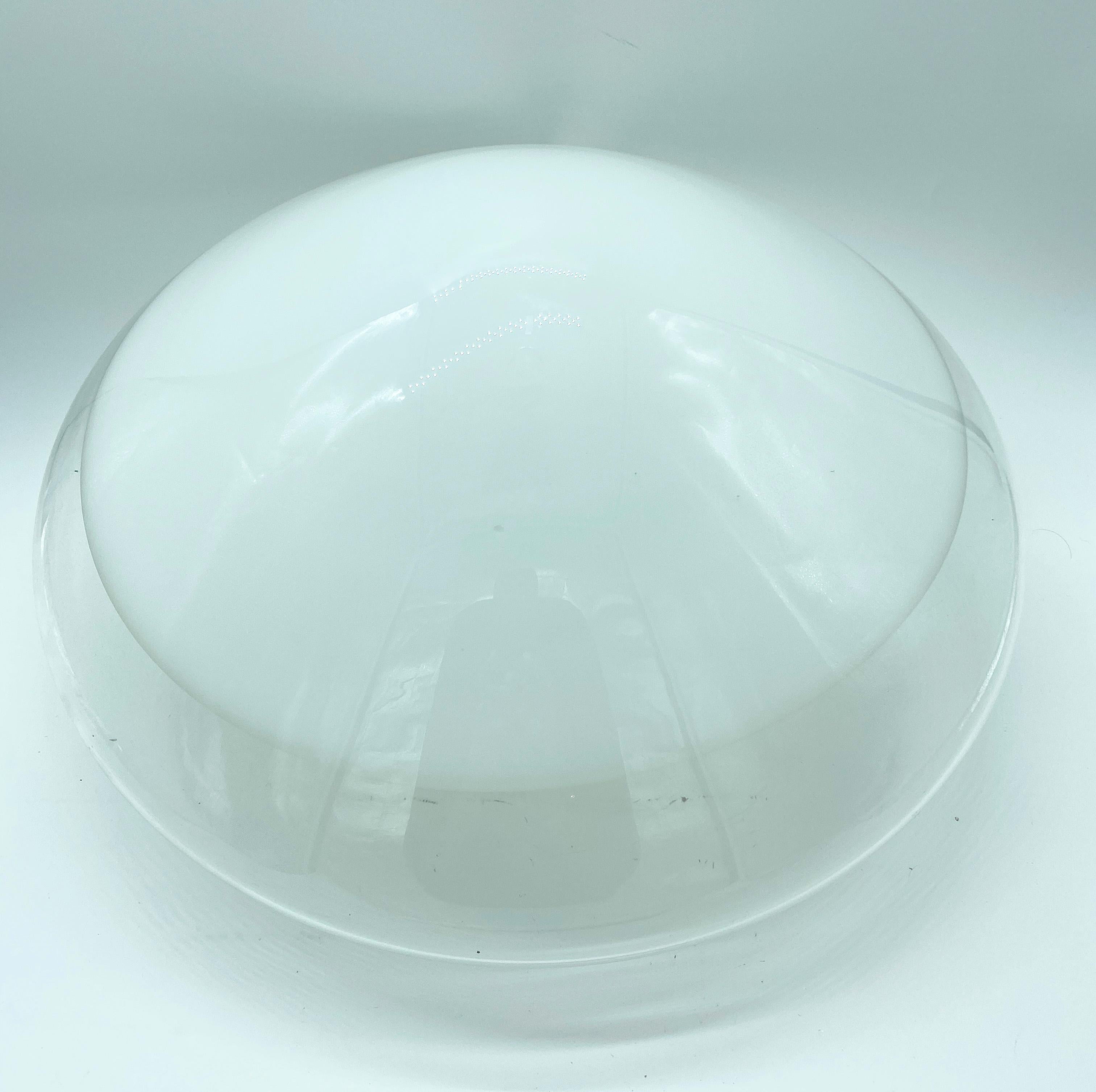 Leucos first designed this in 1962.
This is a wall or ceiling mount featuring a conic, blown-glass diffuser in clear Murano glass with a circular white detail across the front.
The glass diffuser is held in place with three screws that secure it