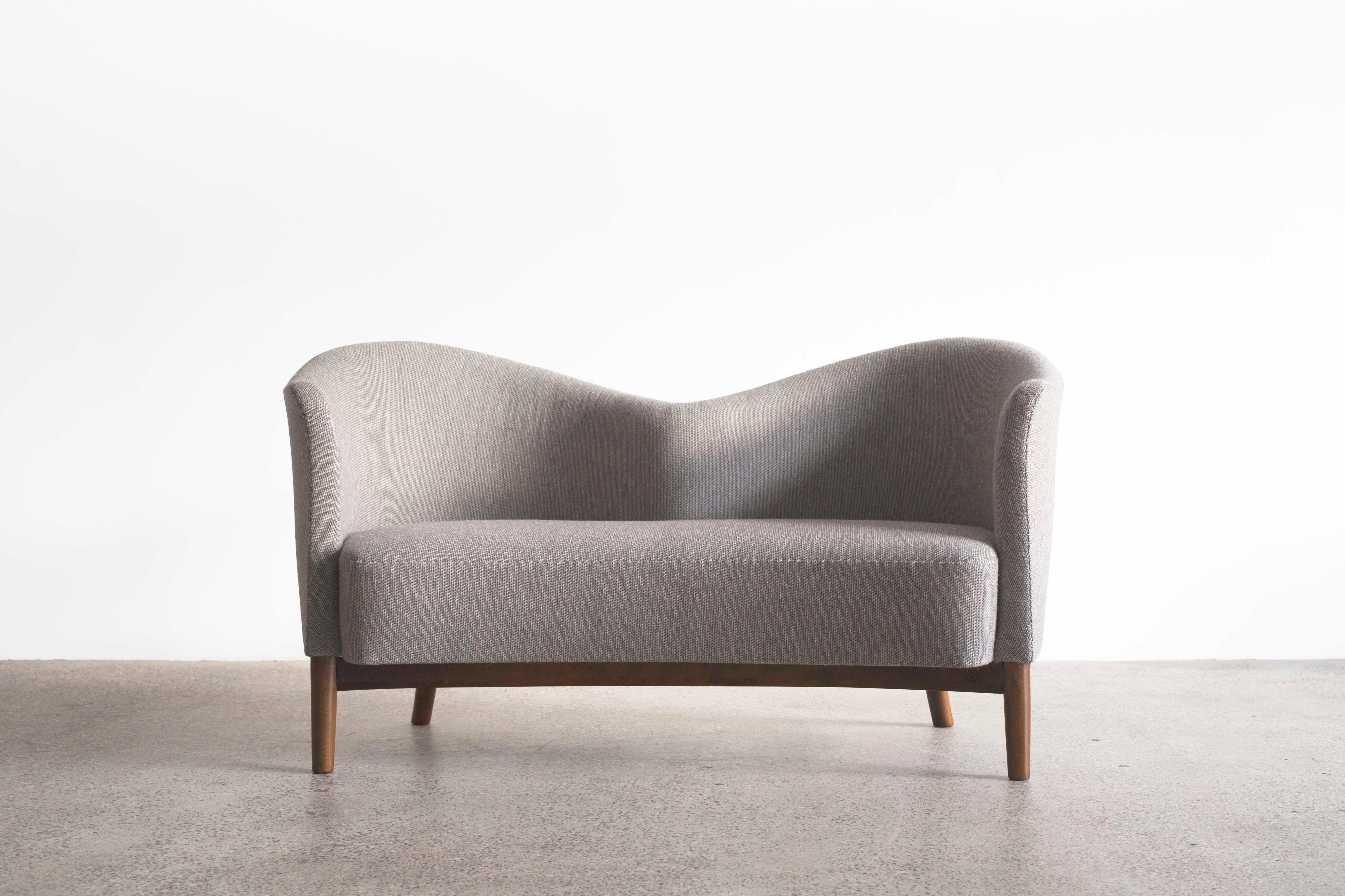 A very rare Nanna Ditzel sofa designed 1949 and executed at cabinetmaker Knud Willadsen, Denmark. 
Legs of stained wood, upholstered with fabric.