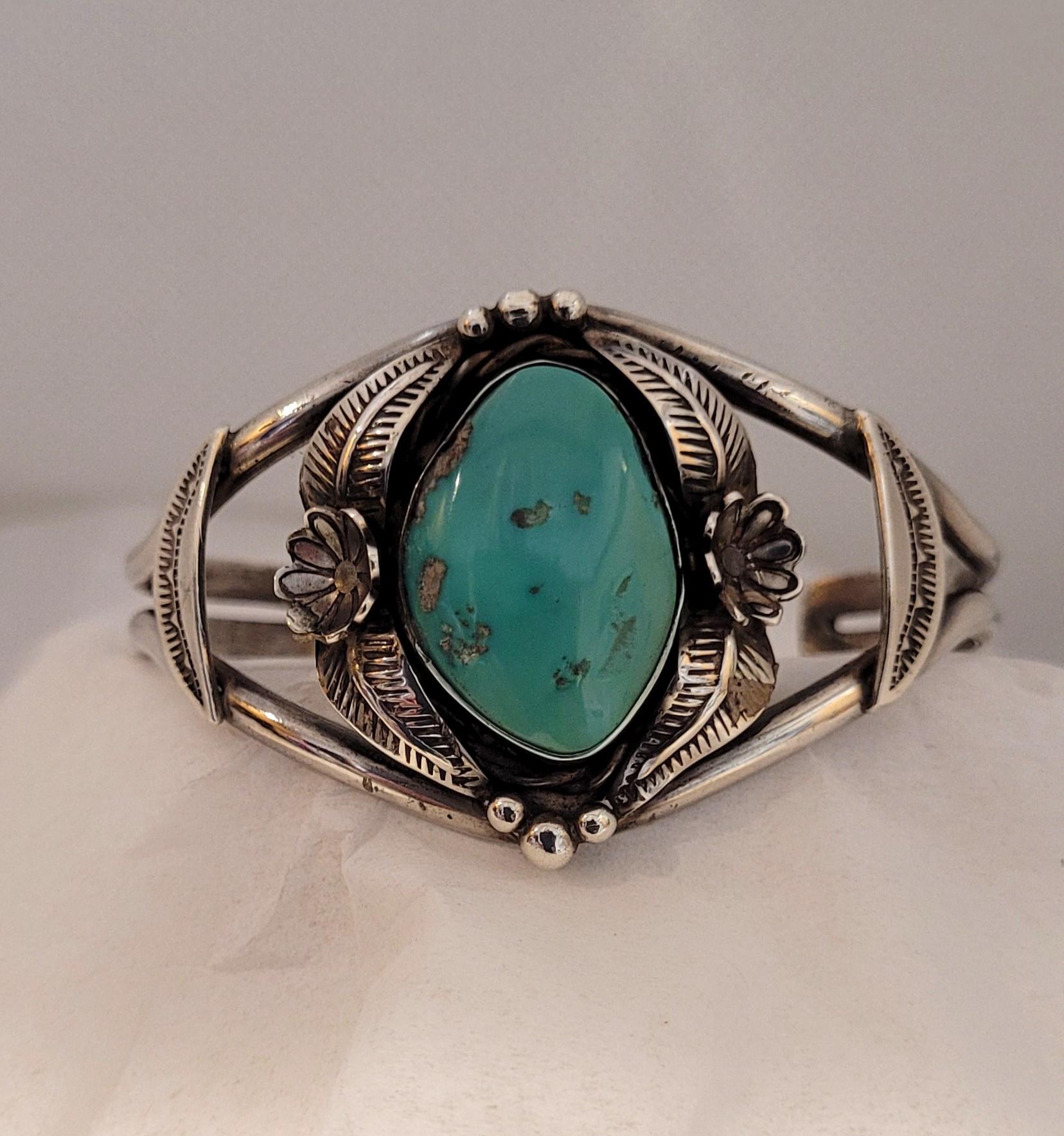 This is a rare turquoise silver cuff bracelet from the Santa Domingo Pueblo, created by the renowned artist Frank Atencio. The stunning silver cuff features an oval, free-form turquoise stone, beautifully complemented by handcrafted, hand-engraved