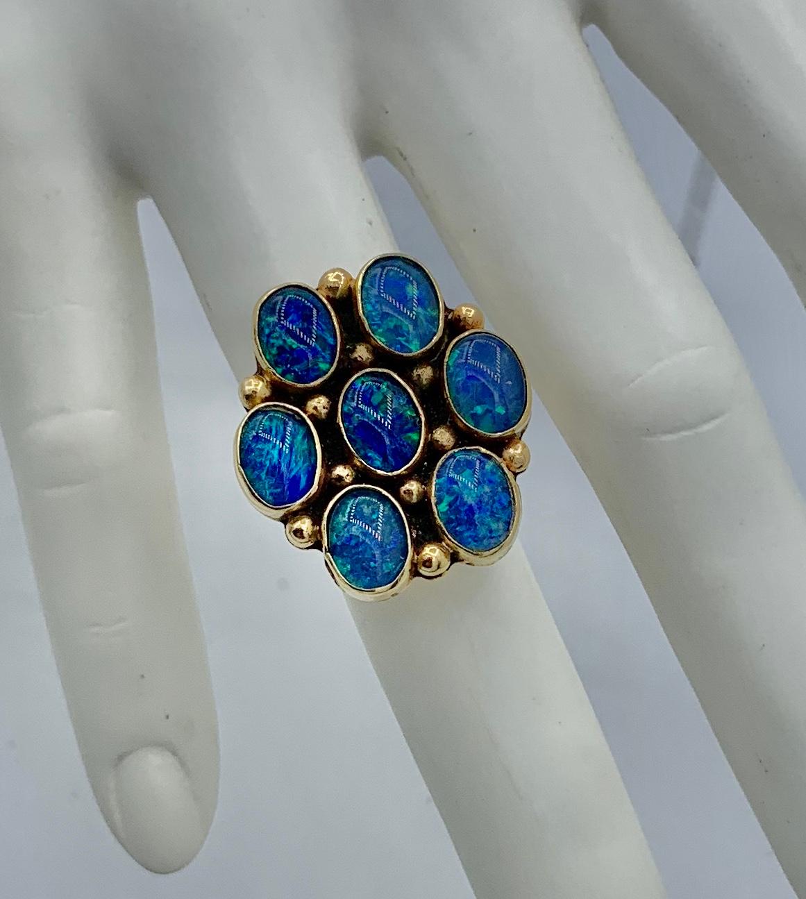 This is a stunning and very rare Black Opal ring in 14 Karat Yellow Gold by the Navajo artist Larry Sandoval and signed with his LS signature.  The large dramatic Native American ring has magnificent oval Black Opals.  The seven opals are in a