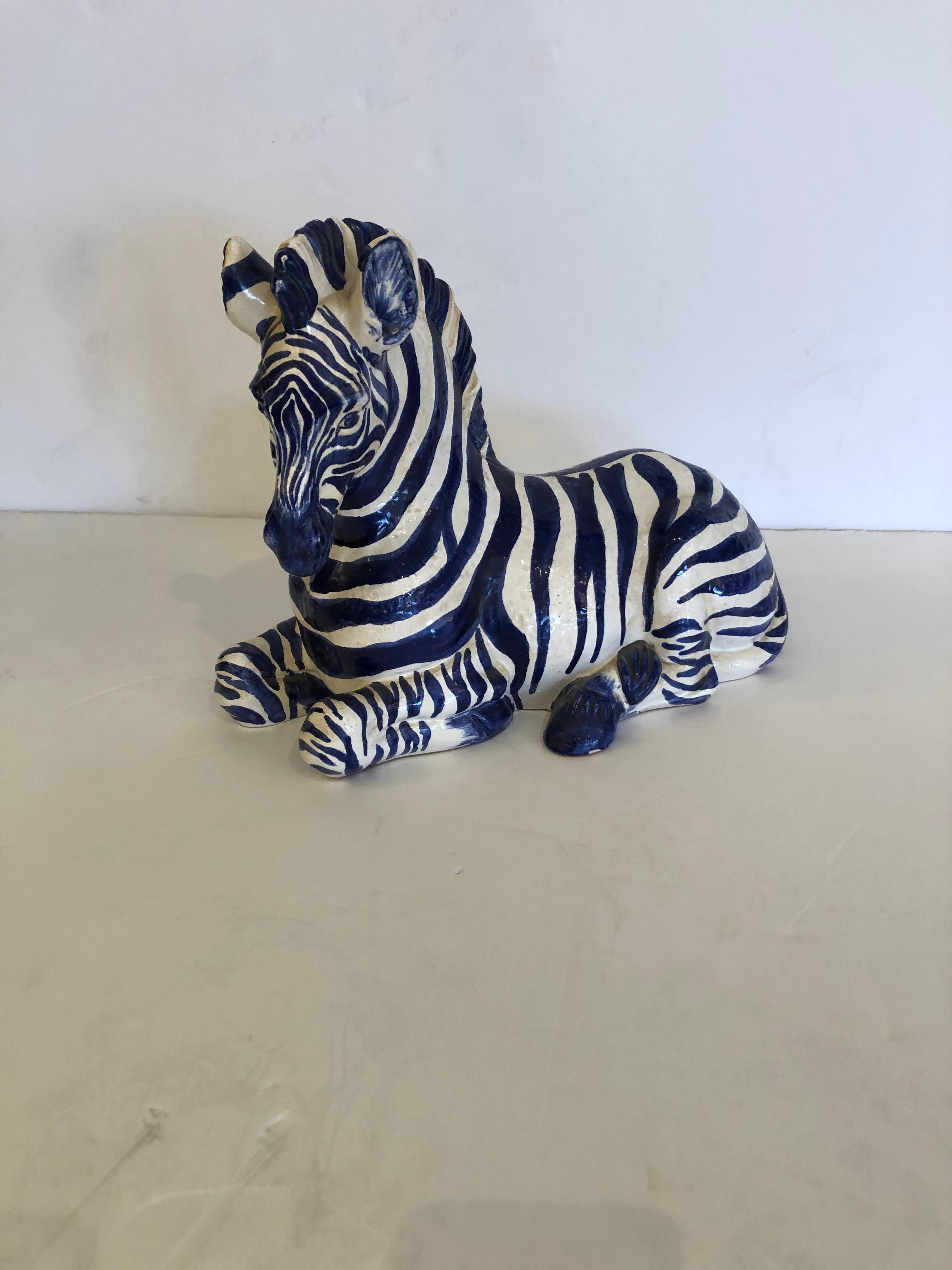 Eye-catching Italian ceramic recumbent zebra sculpture in a rare blue and white color palette.