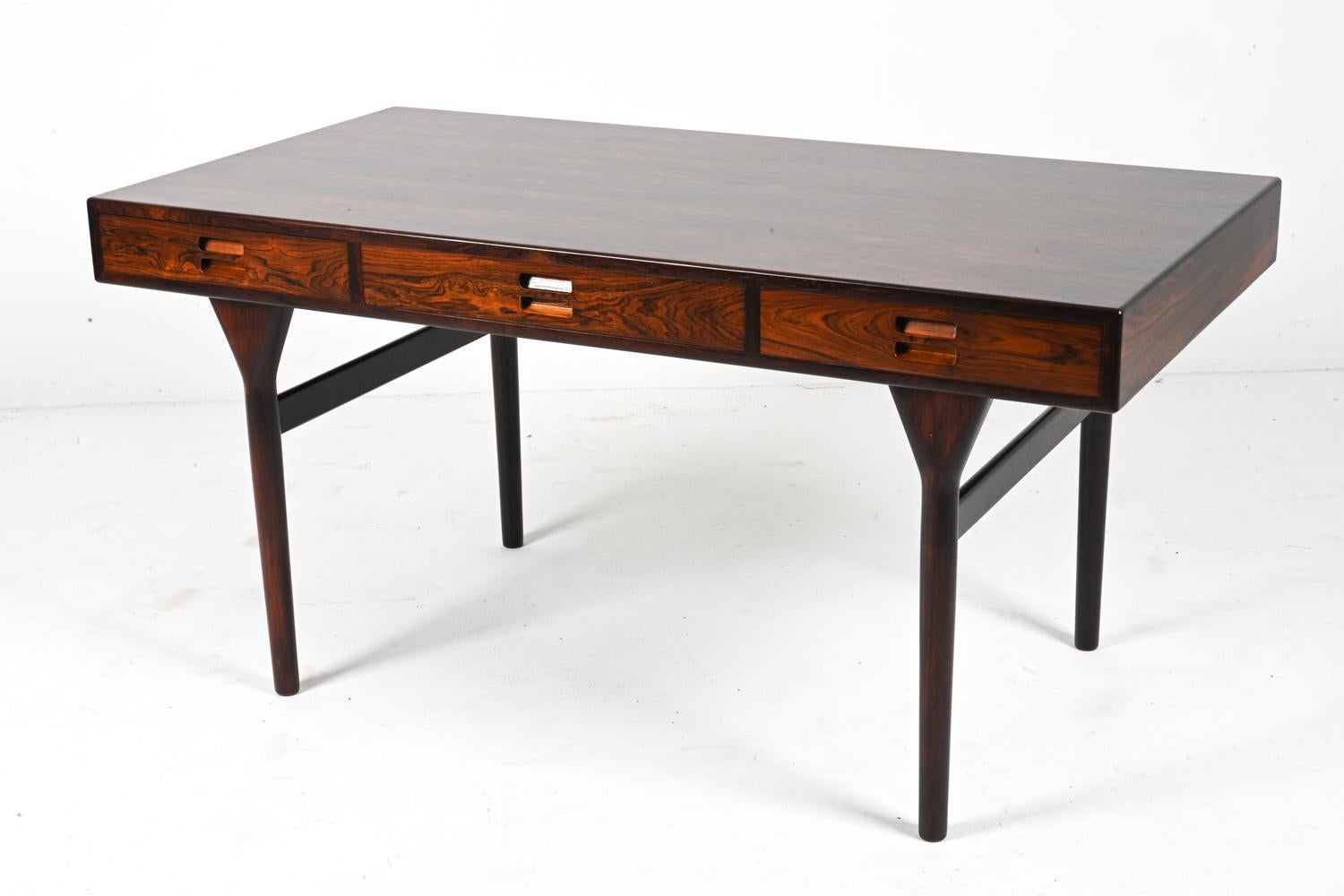 Introducing the exquisite Model ND93 writing desk in rosewood, a timeless masterpiece crafted by the renowned Danish designer Nanna Ditzel for Søren Willadsen in the 1950s. This iconic mid-century modern desk seamlessly blends functionality and