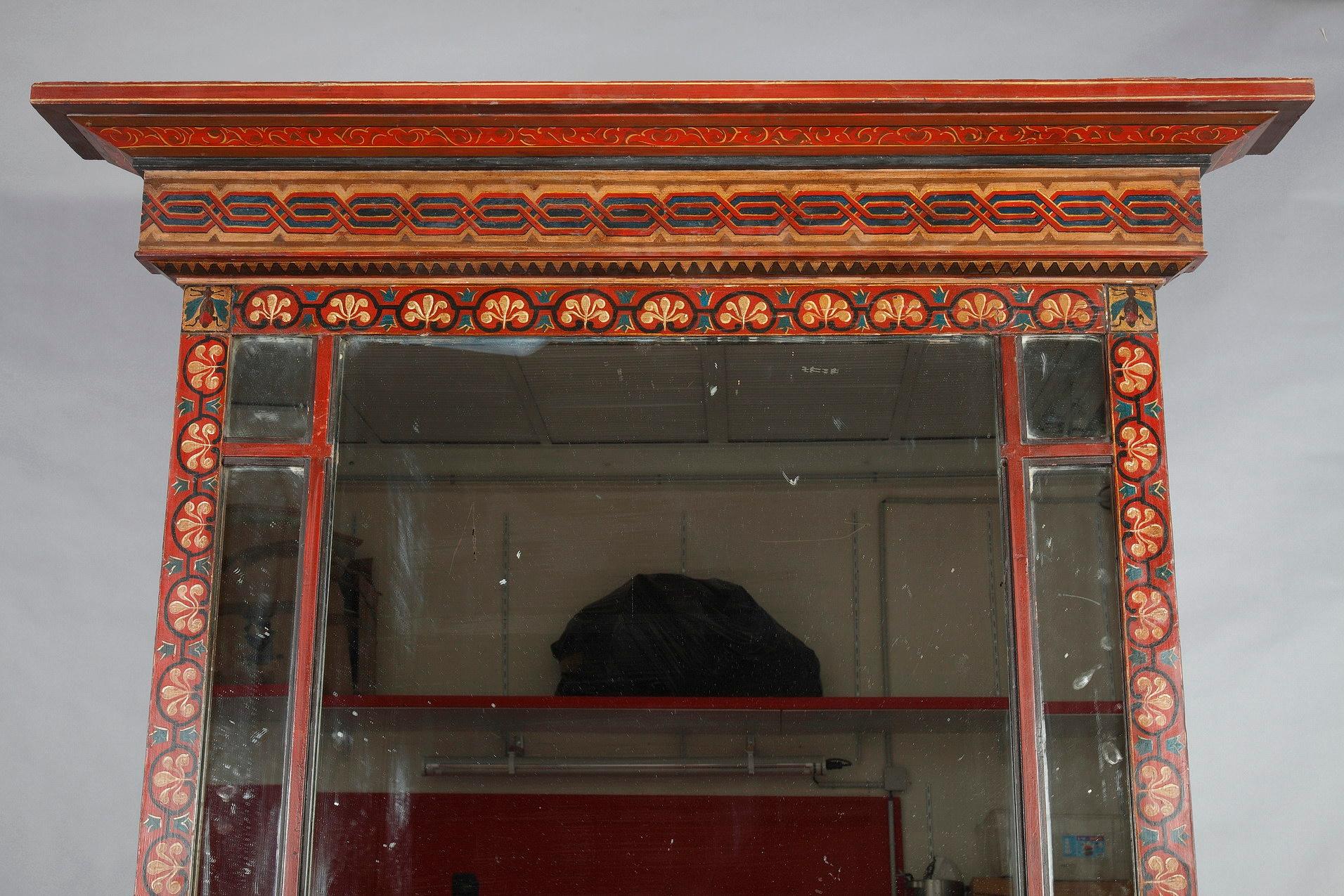 Charming painted wood neo-Pompeian console and its mirror. The console, resting on four feet, is decorated with olive branches, two-tone triangle friezes and frieze of flowers on the belt, on a red background. The console is surmounted by a large