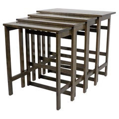A nest of four side tables each top surface hand painted with floral decoration.