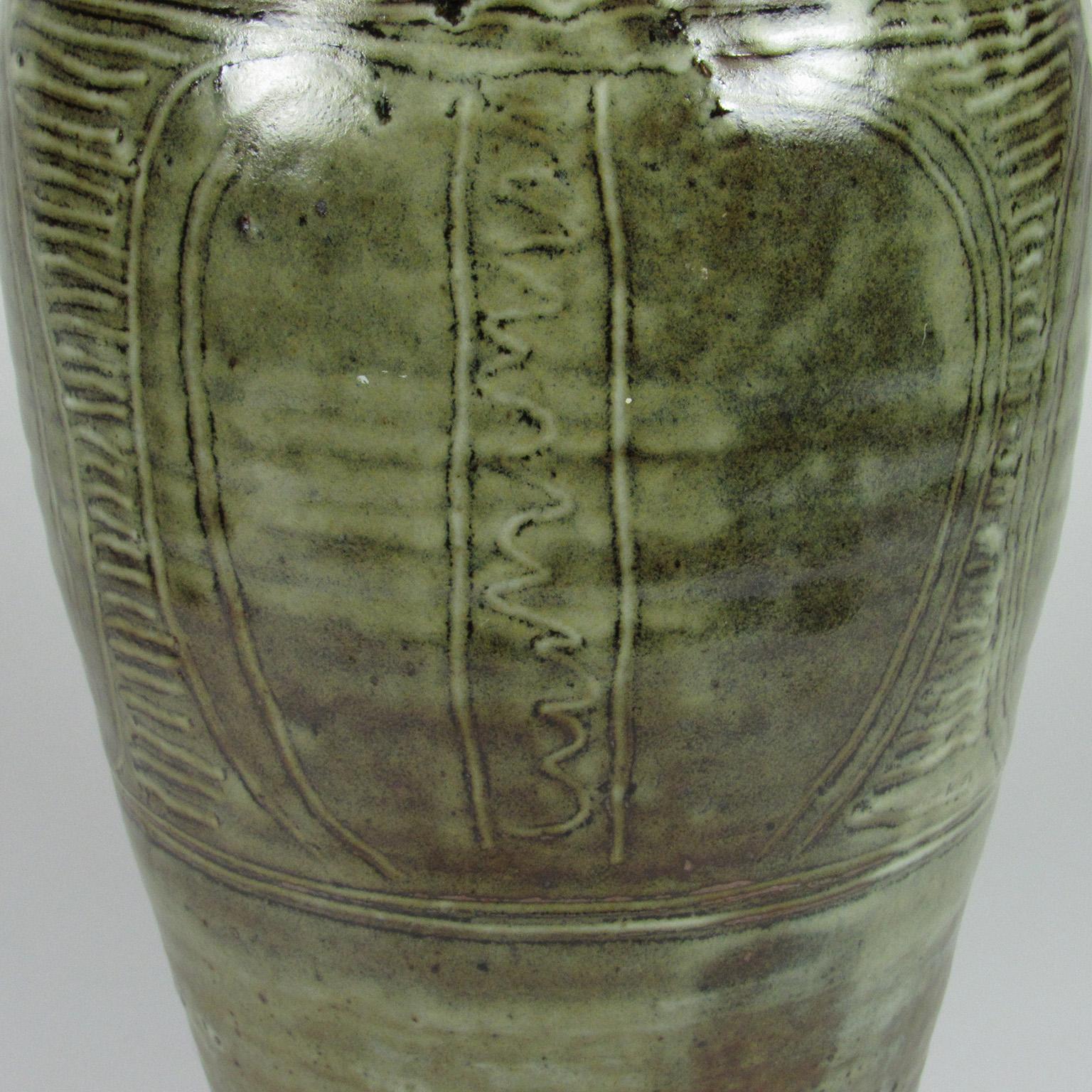 Nigerian mid-20th century Abuja Pottery four handled vase by Bawa Ushafa under Michael Cardew. This elegant tall vase has incised decoration with a celadon green and oxidized iron red glaze. Signed on foot 