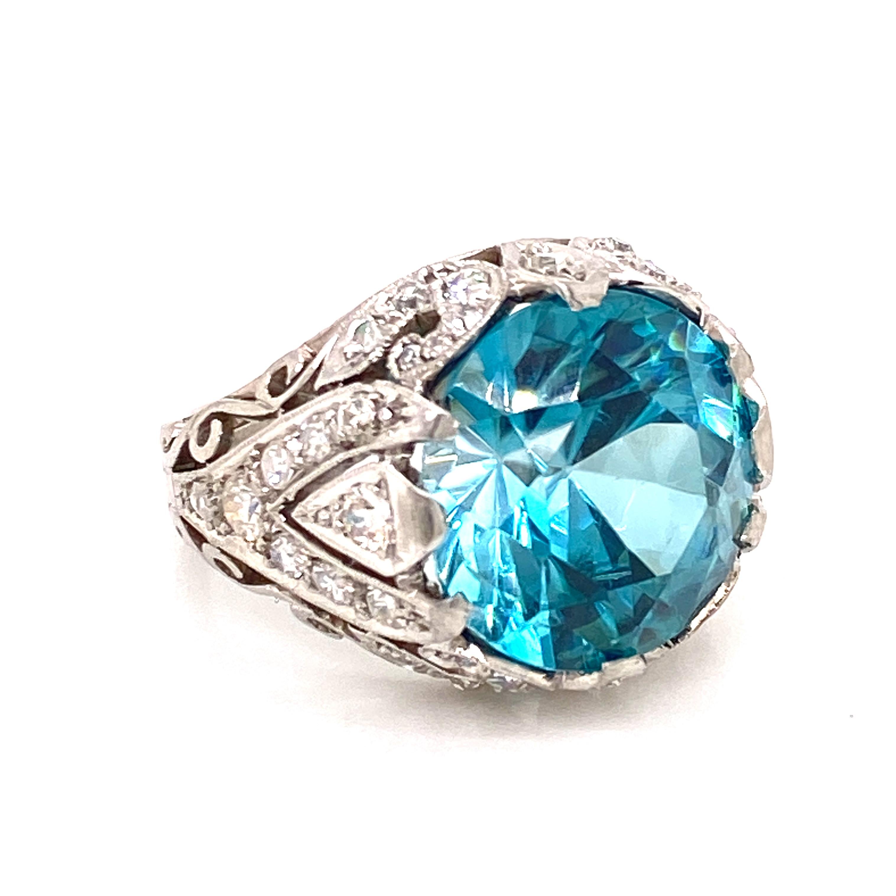 Gorgeous Natural Blue Zircon gemstone set in a hand crafted diamond mounting. The 11.74 carat round blue zircon has not had any heat or color treatment. AGL certificate included. The zircon measures 13.4 x13.2mm, and is set in a beautiful handmade