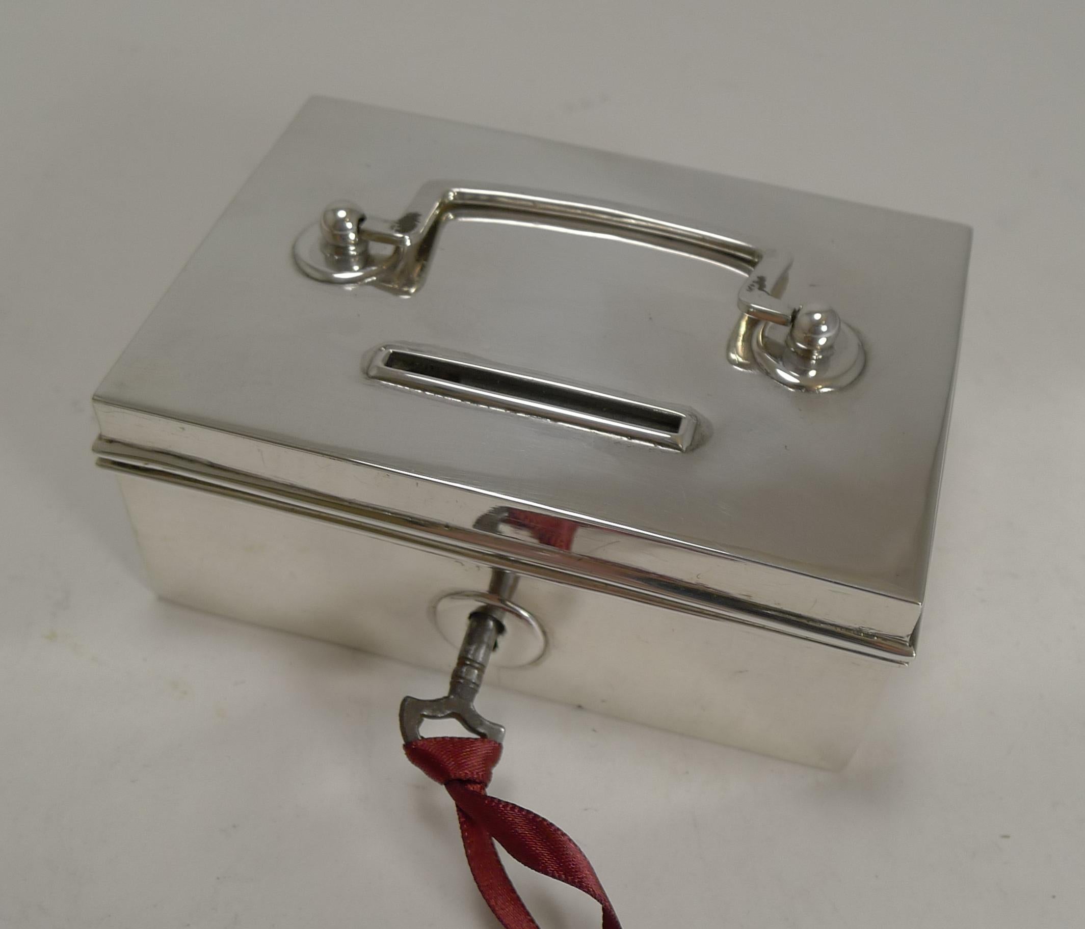 A rare and highly sought-after sterling silver money box or bank, the like of which I have never seen before.

The box is made from English sterling silver in the form of a miniature cash box including the swing handle to the top.

The box comes