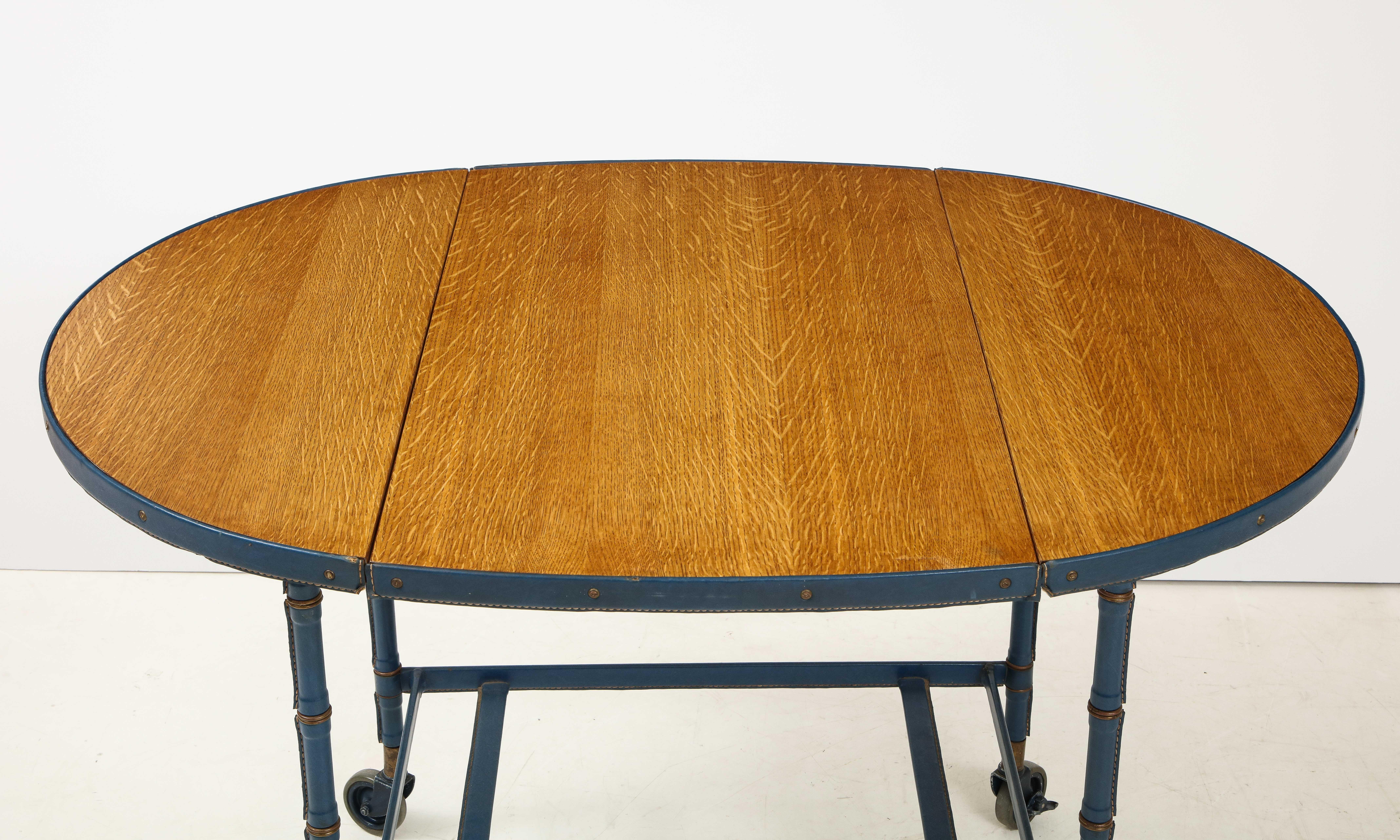 Milieu du XXe siècle Rare table / chariot de bar en chêne et cuir bleu surpiqué par Jacques Adnet en vente