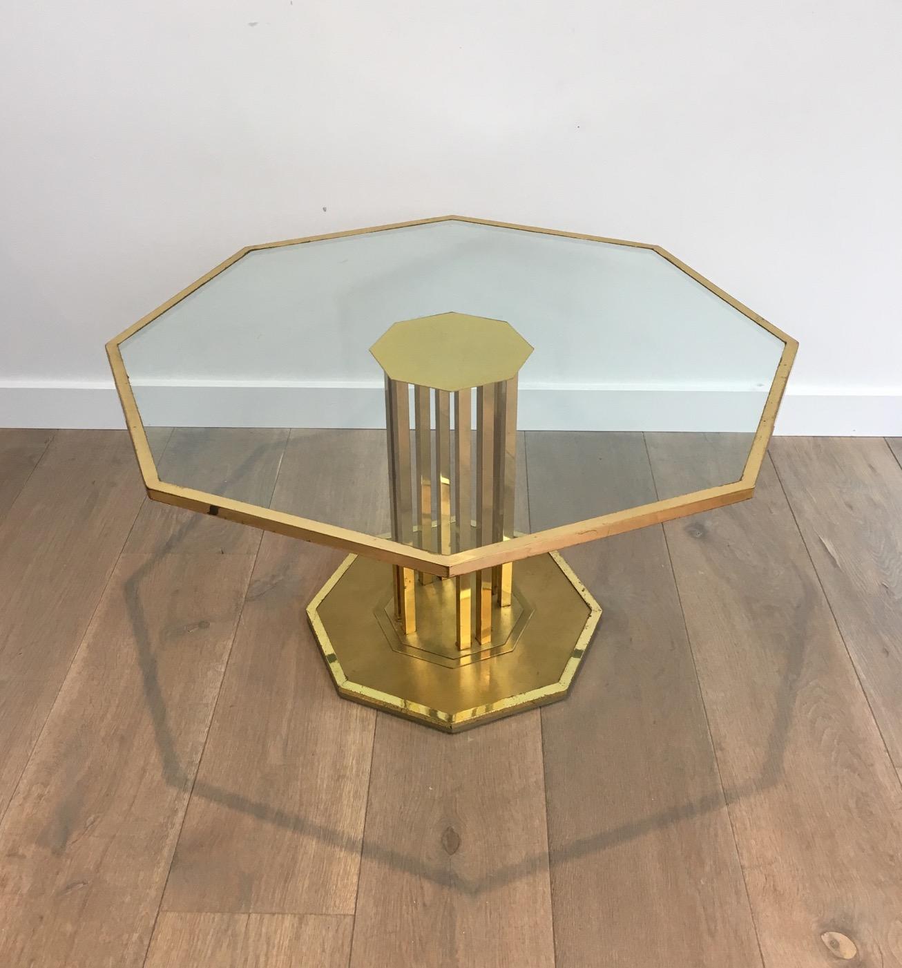 This rare octagonal design coffee table is made of a beautiful brass base with an octagonal glass top. The glass is original so can have some small scratches. This is a French work. Circa 1970