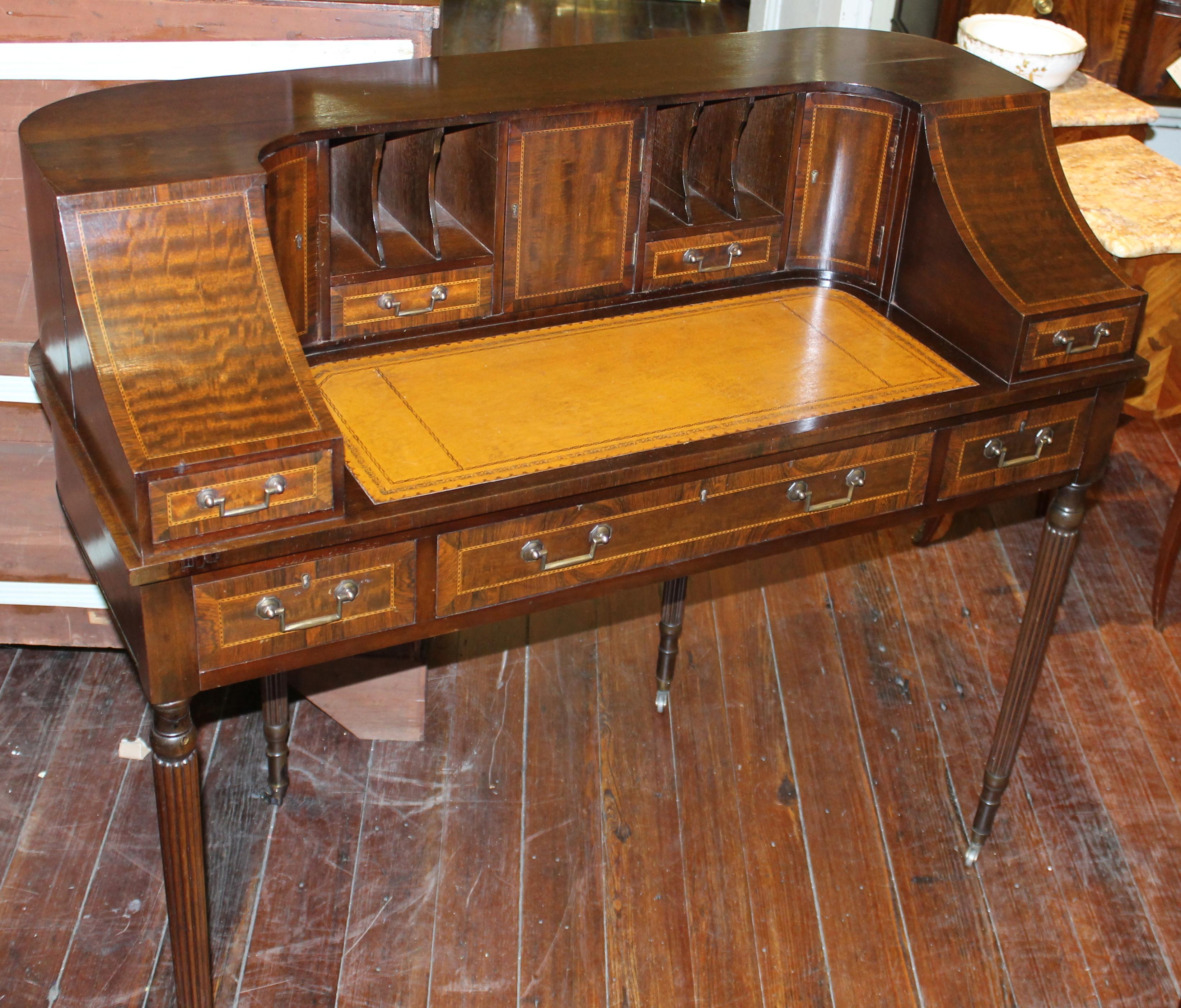 Rare and fine Old English inlaid mahogany leather top Carlton House desk; fitted drawers and pigeon holes. Hand dovetailed mahogany lined drawers. Handsome reeded round and tapered legs. Tan tooled leather hide writing surface.

Measures: 25