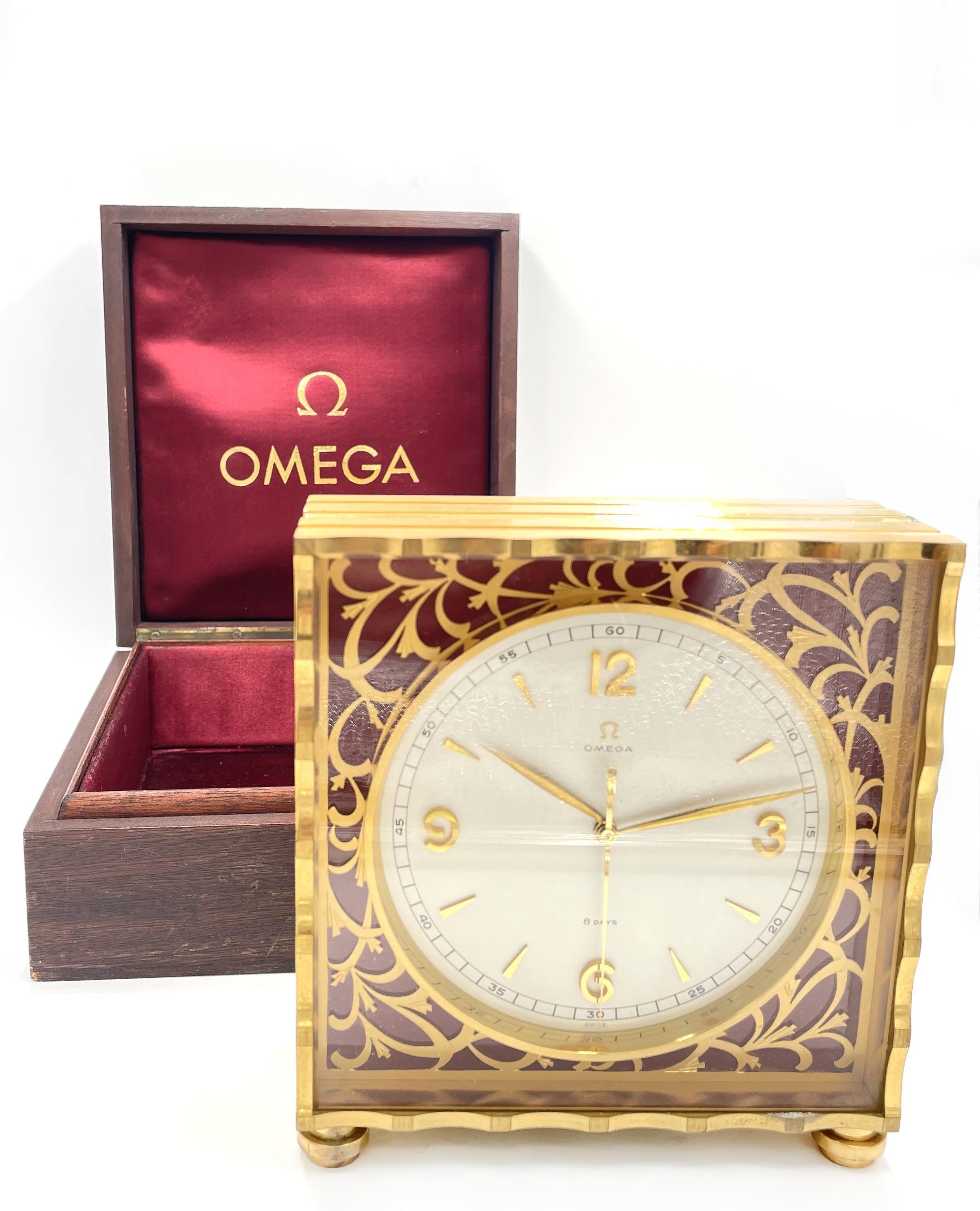 Original Antique Omega 8-Day Solid Brass Gold Gilt Desk Clock. Pierced floral dial surround over red background. Hinged panel on back opens to reveal a beautiful exhibition mechanical wind movement, marked 