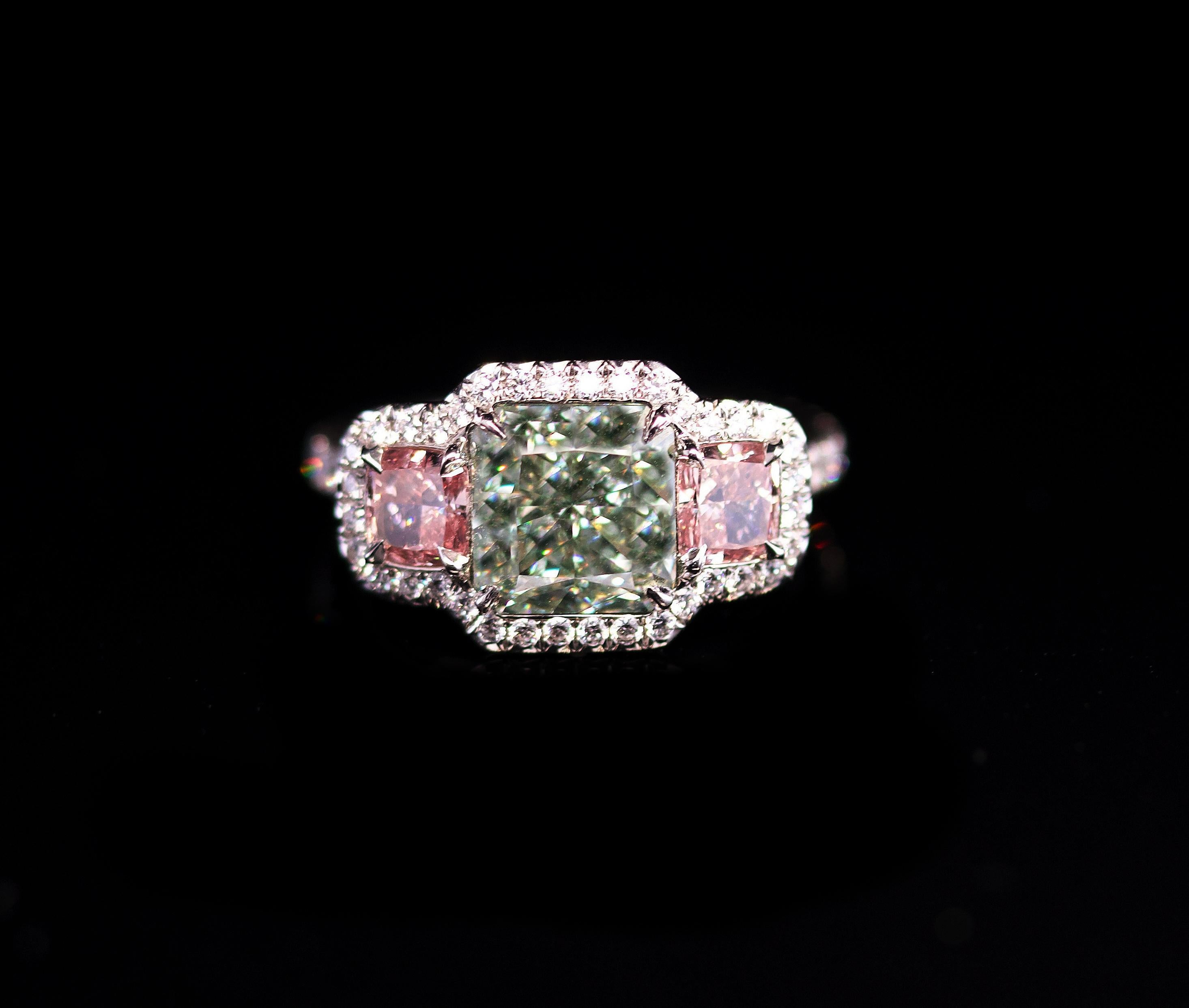 This is a RARE diamond ring!
Green diamonds are rare and the more intense their color is, the rarer they become, like this diamond.
This beautiful Green Diamond is set in a platinum ring with 2 Natural Fancy Pink diamonds on the side. 
This kind of