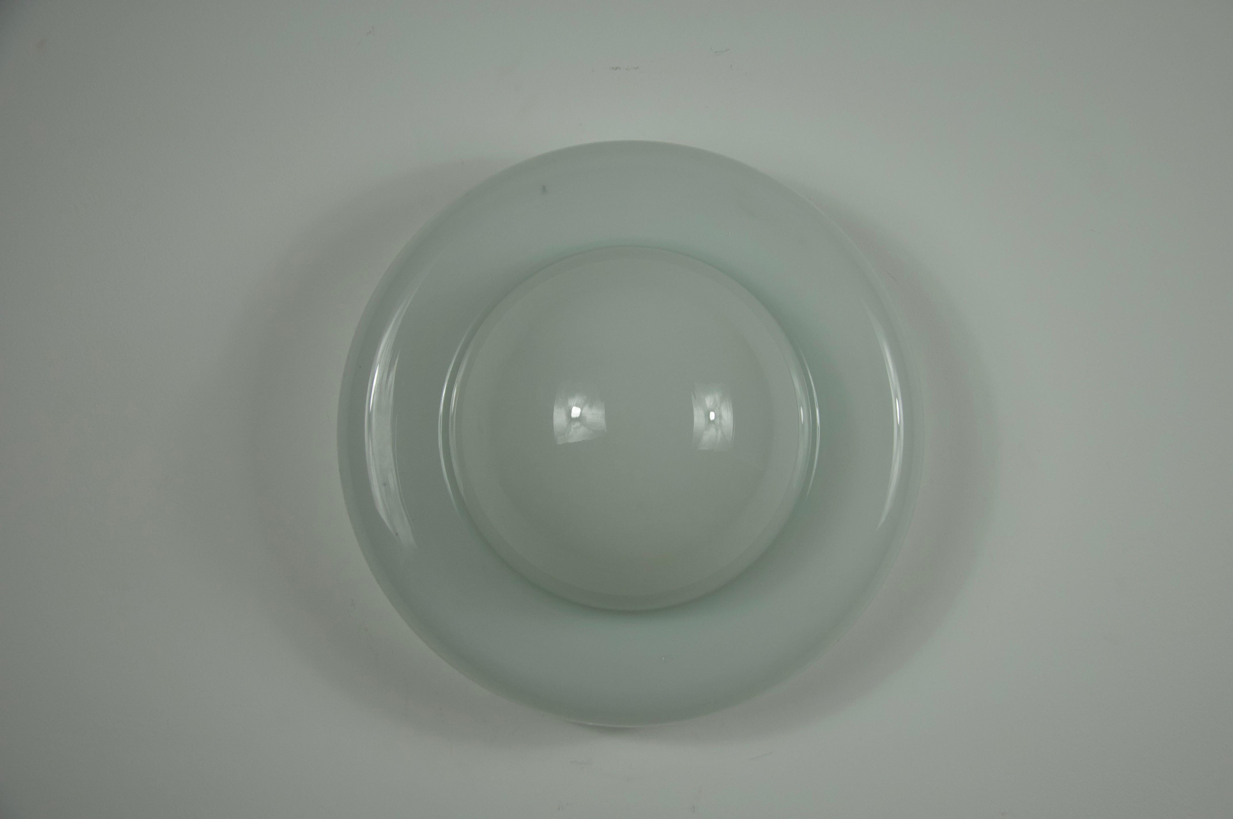 Diese seltene Opalglas-Wandleuchte aus den 1960er Jahren ist ein schönes Beispiel für italienisches Beleuchtungsdesign aus der Mitte des Jahrhunderts. Die Lampe hat eine weiche, organische Form mit einer sanft gerundeten Silhouette, die das Licht