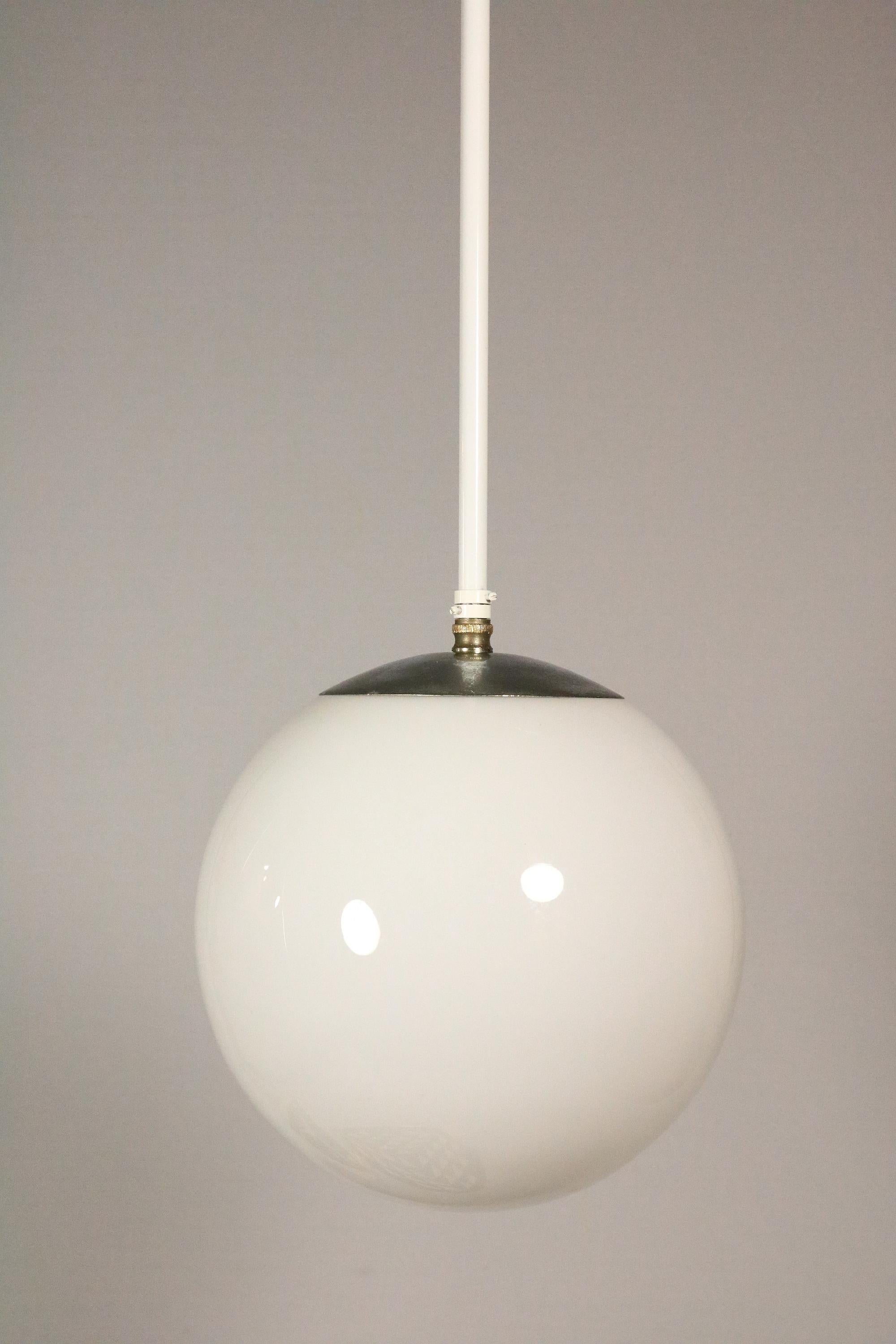 Classic Light from the 1940s 1950s
Danish ball lamp made of opaline glass.
 
Well preserved with signs of use on the metal cover.
New white painted pendant rod and new wiring.
 
Height: 75 cm / 29.5 inch
Diameter: ca. 25 / 10 inch

Tables are not