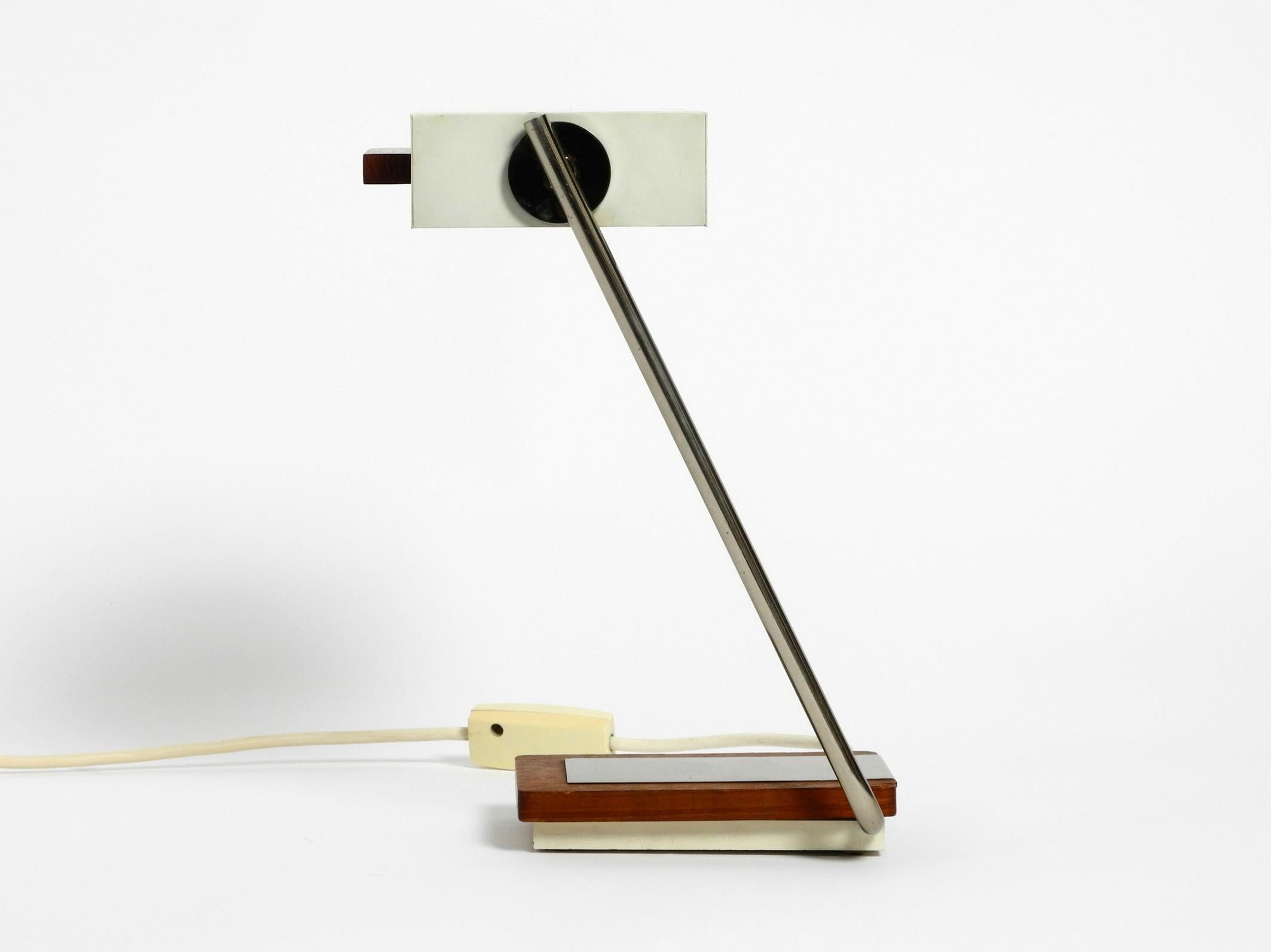 Original 1960s Kaiser light table lamp with teak base and infinitely swiveling metal neck.
The shade is made of metal in ivory white.
Beautiful minimalist design from the 1960s.
Lampshade can also be adjusted.
Fully functional and in a very good