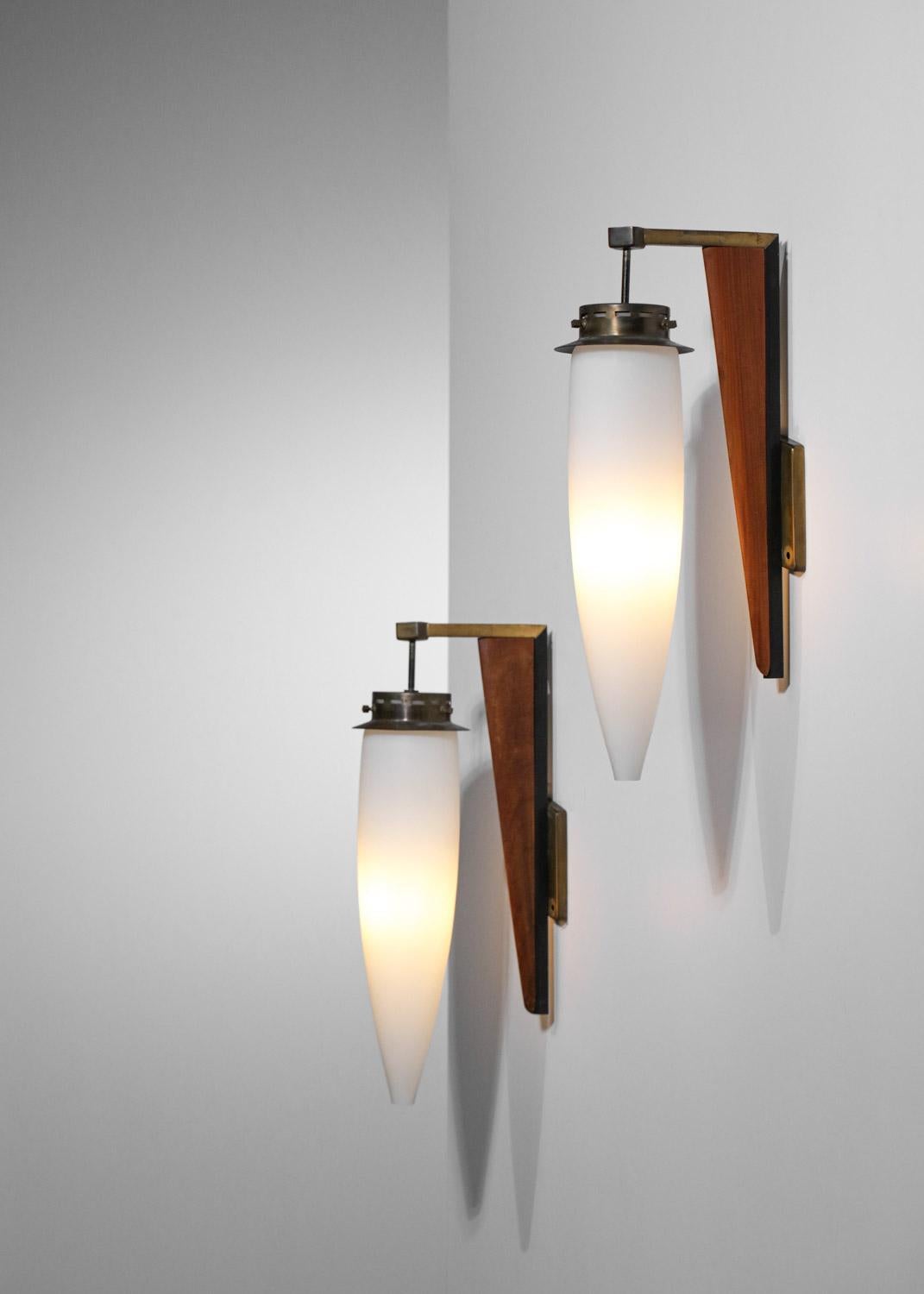 Pair of vintage Italian sconces published by Stilnovo in the 50s. Structure of the sconces in solid teak and brass, diffusers in white opaque opaline. Sober and elegant design approaching the Scandinavian design of the same period. Very nice vintage