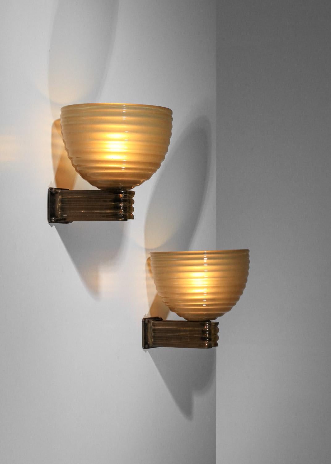 Large pair of Italian sconces by designer Tomaso Buzzi from the 60s. Structure and shade in thick Muranno glass in gold / yellow hues. Very fine vintage condition, with slight traces of age and use. Original electrical system, use E27 LED bulbs