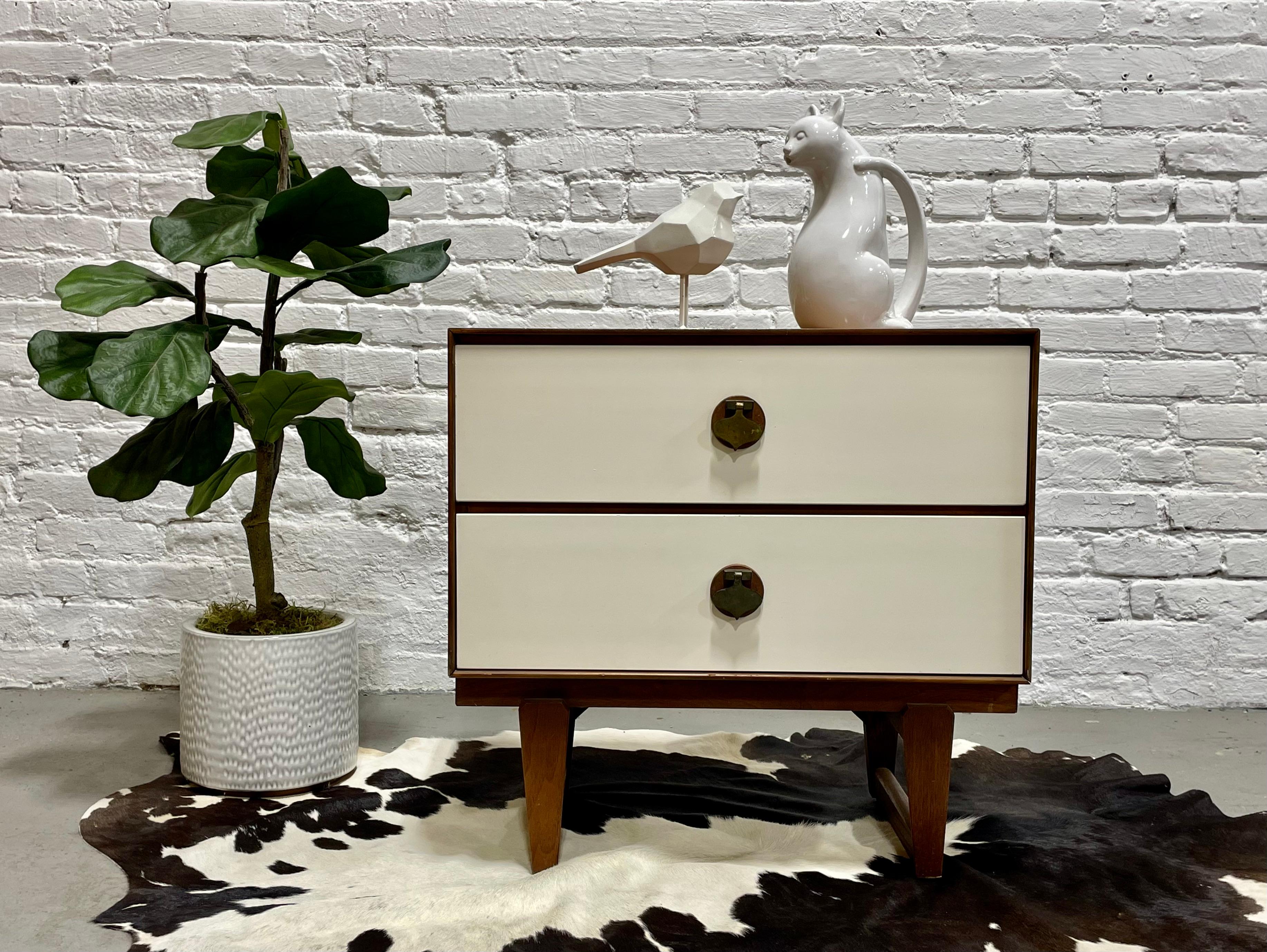Rare + Original Mid Century Modern White & Walnut Nightstand by Stanley Furniture Co., c. 1960's. This elusive series was in limited production and is incredibly hard to find. The nightstand is highlighted by solid brass spade pulls over solid