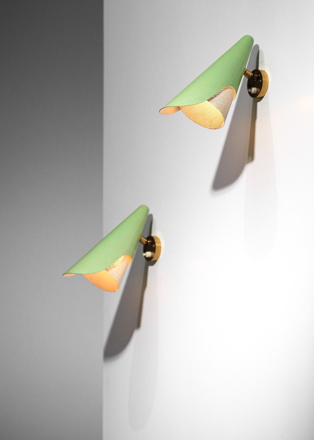 Pair of Italian wall sconces from the '60s by Stilux. Wall plate and central ball-and-socket joint in solid brass with patina finish, allowing the lampshade to be oriented. Light green lacquered metal lampshade and white lacquered rigitulle
