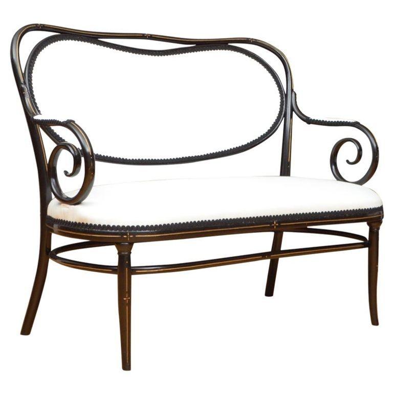 Rare canapé ébonisé de Thonet, avec une traverse supérieure en forme, un dossier en forme de rein, une assise généreuse et des accoudoirs en volute ouverts, reposant sur des pieds extérieurs, le tout avec des décorations dorées sur l'ensemble. Ce